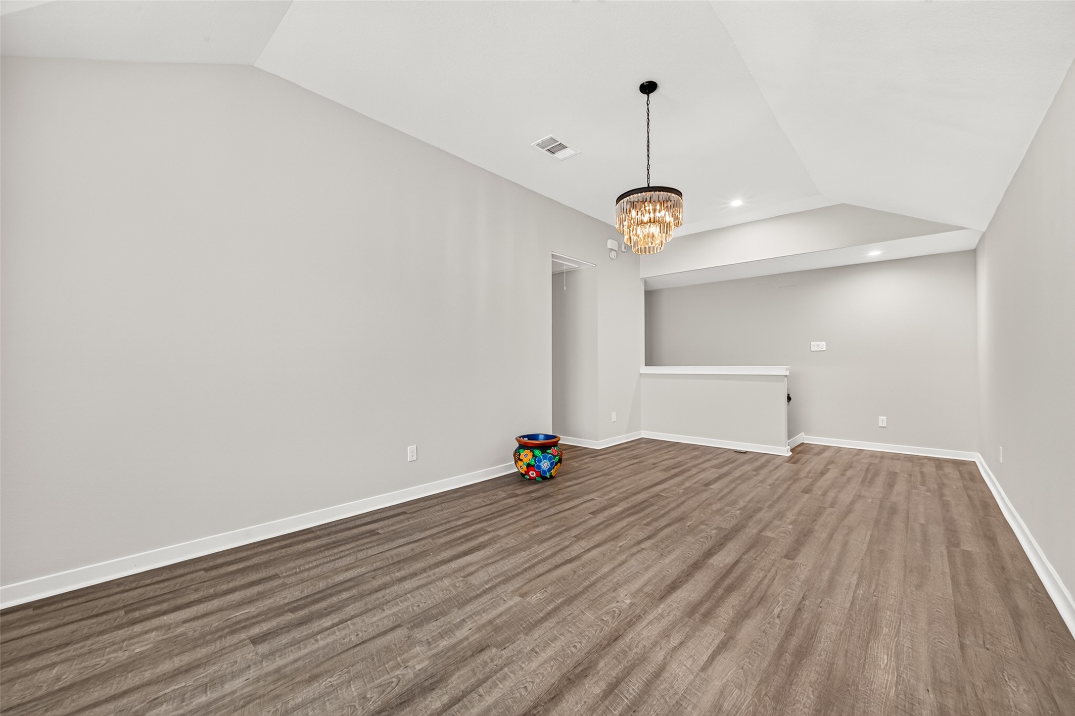 This reverse view highlights the game rooms generous layout and continuous wood-look flooring.