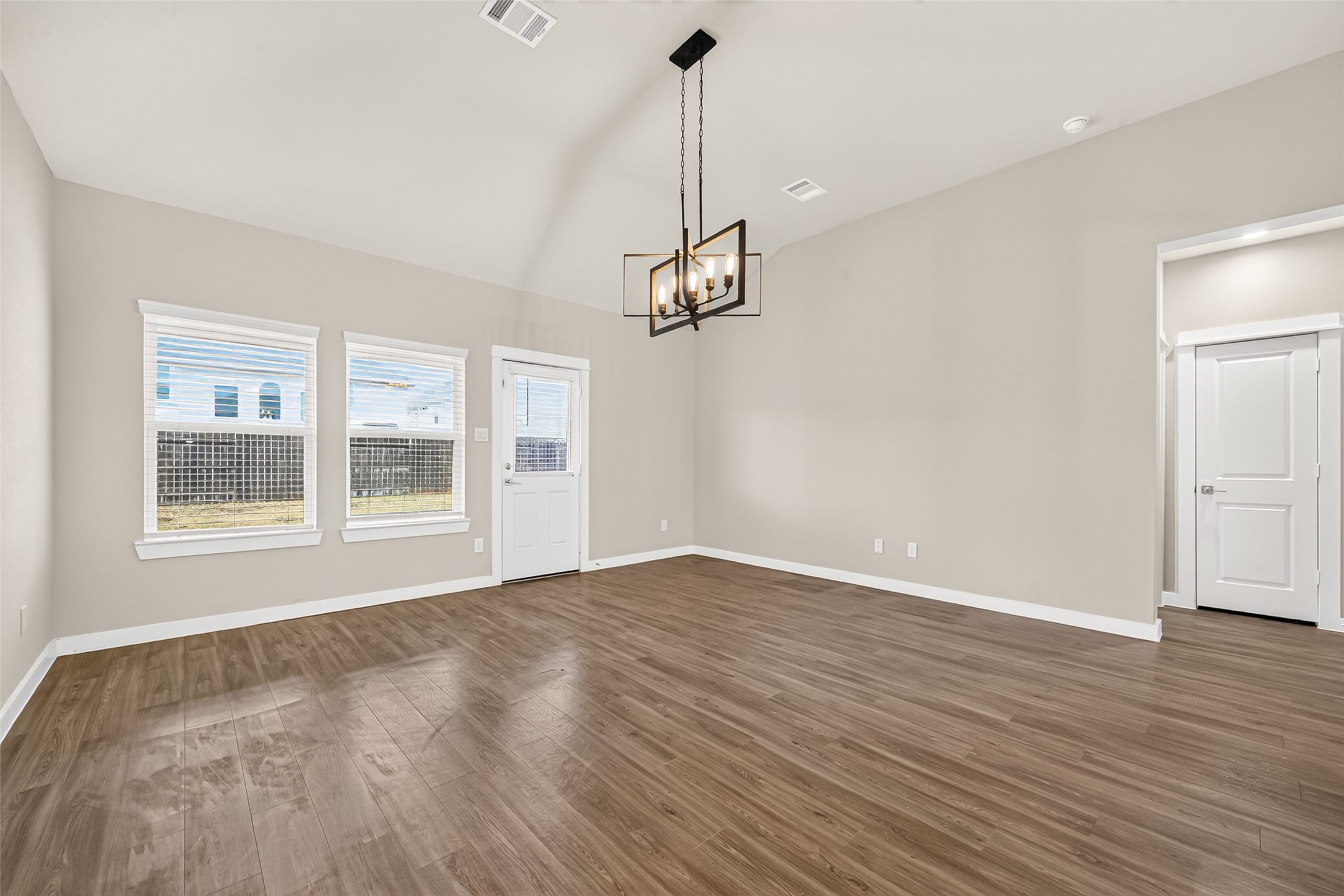 Backyard-facing windows bring natural light into the family room, with a nearby door leading to the covered patio.