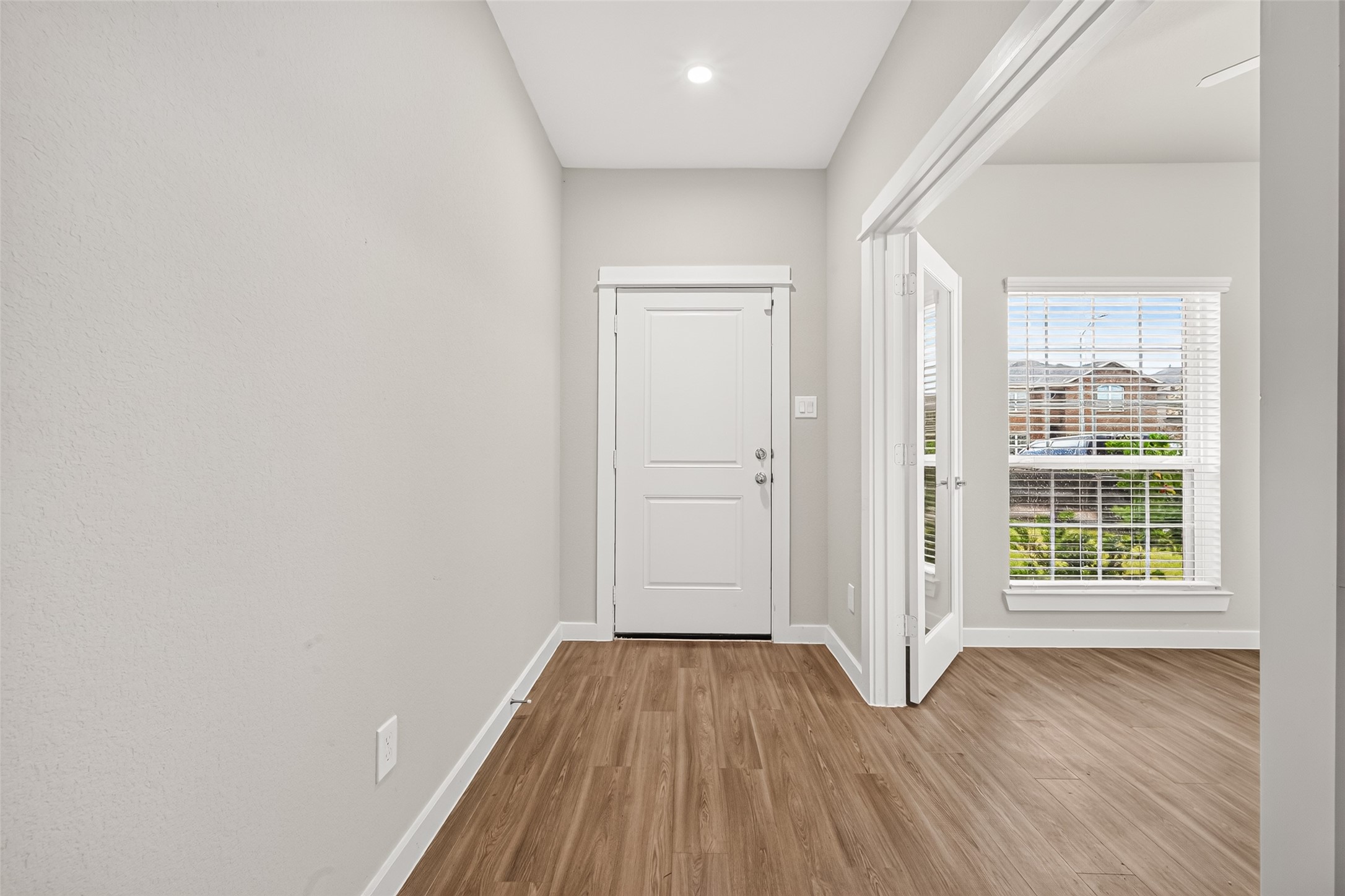 The entry hallway welcomes you with neutral finishes, wood-look flooring, and convenient access to the study.
