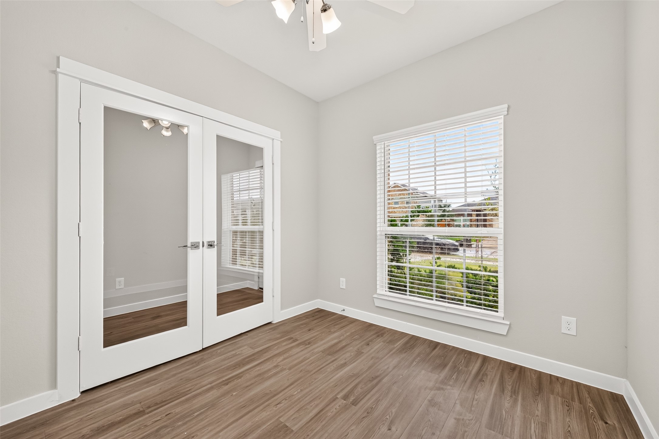 Glass double doors frame the private study, offering a dedicated space for working from home, reading, or creative projects.