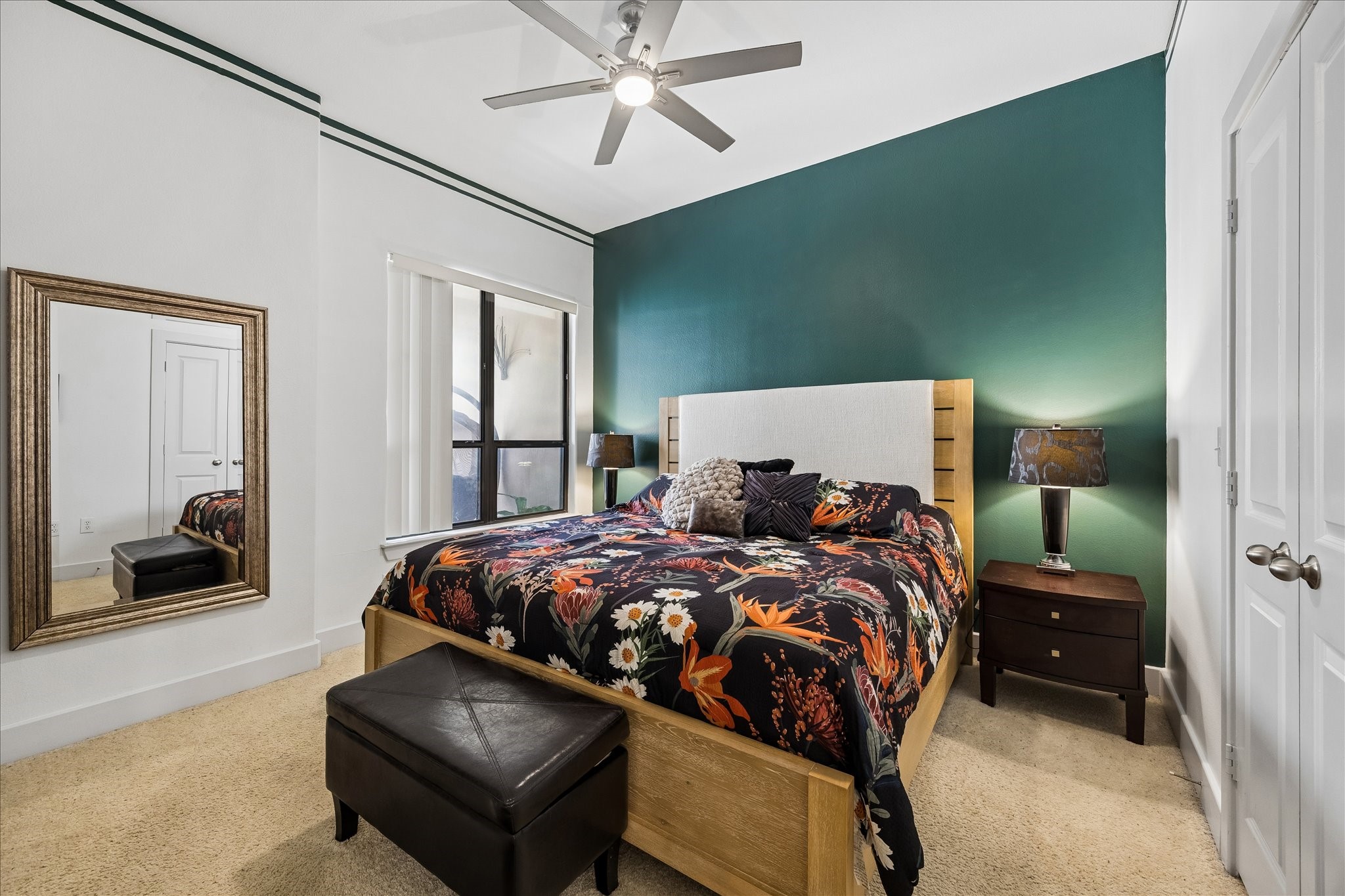 Primary bedroom with high ceilings, accent wall, and large walk-in closet.
