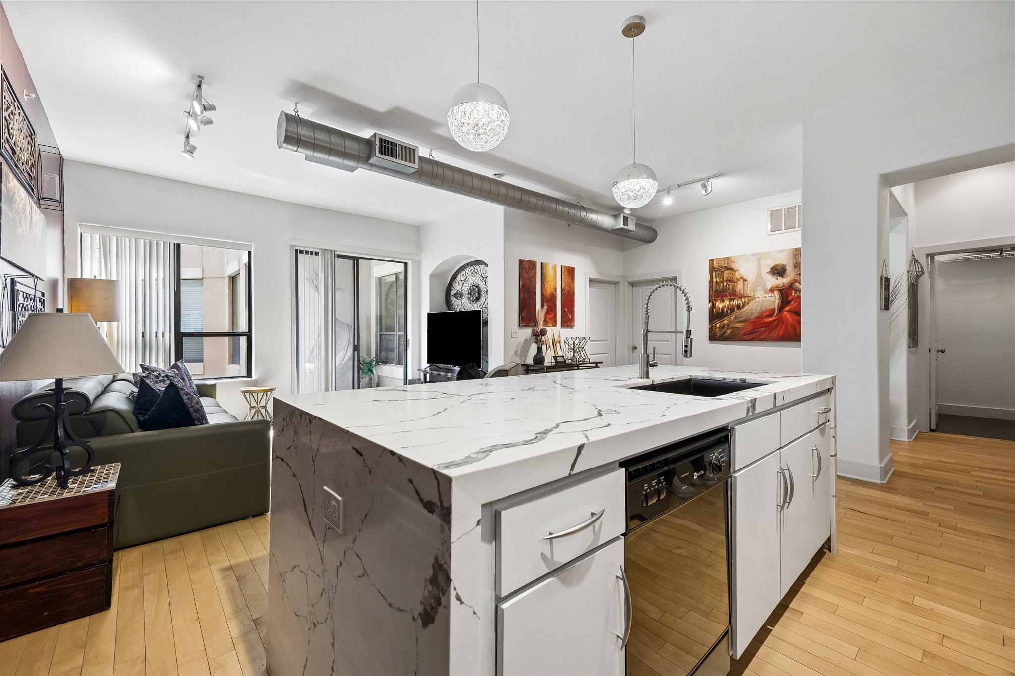 Oversized waterfall quartz island anchors the kitchen and living space.