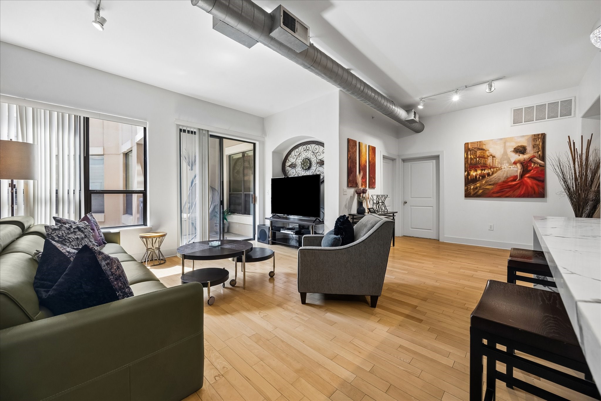 Spacious living area with hardwood floors and access to the covered balcony.