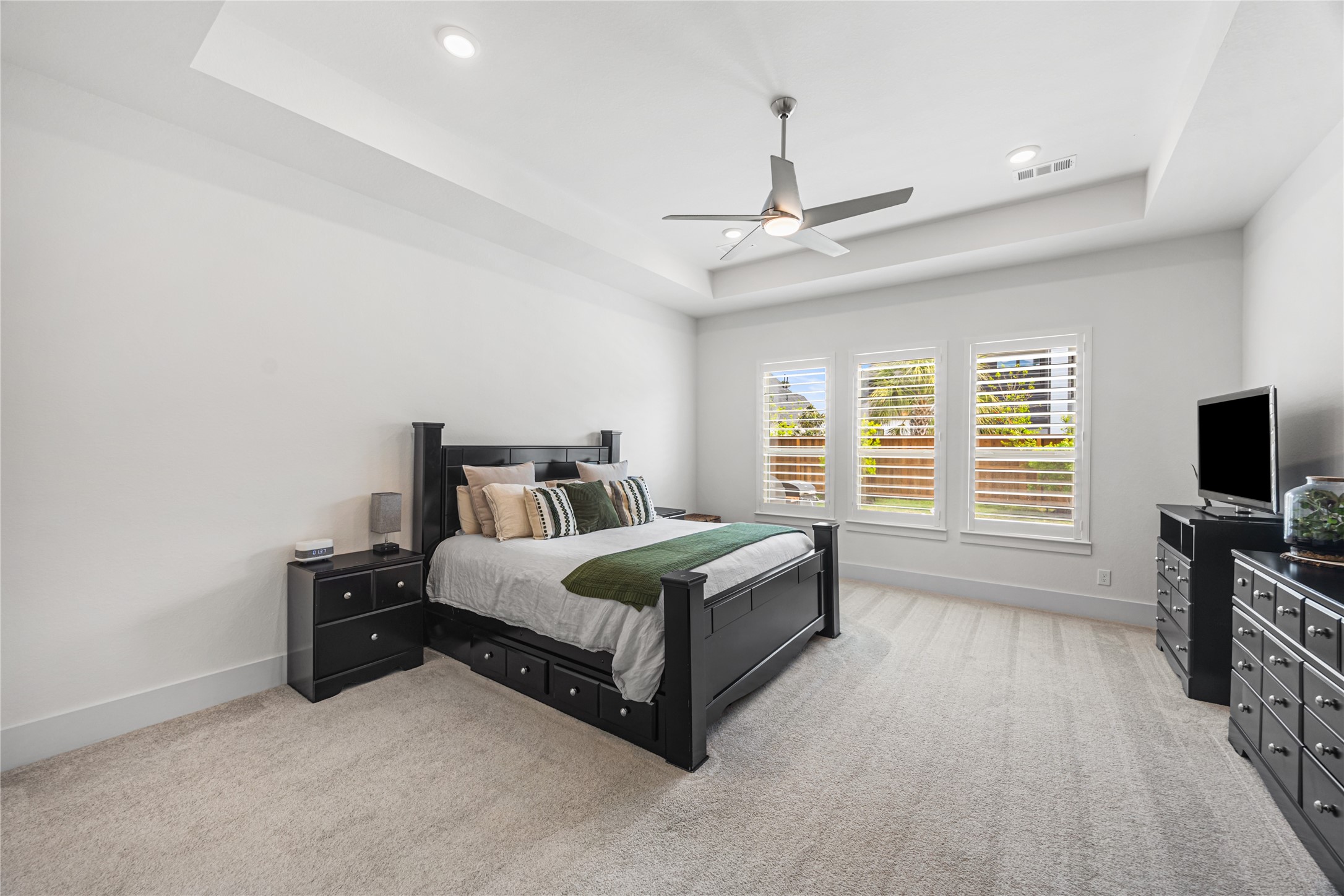 Oversized primary bedroom filled with natural light from large windows, offering a spacious and serene retreat.
