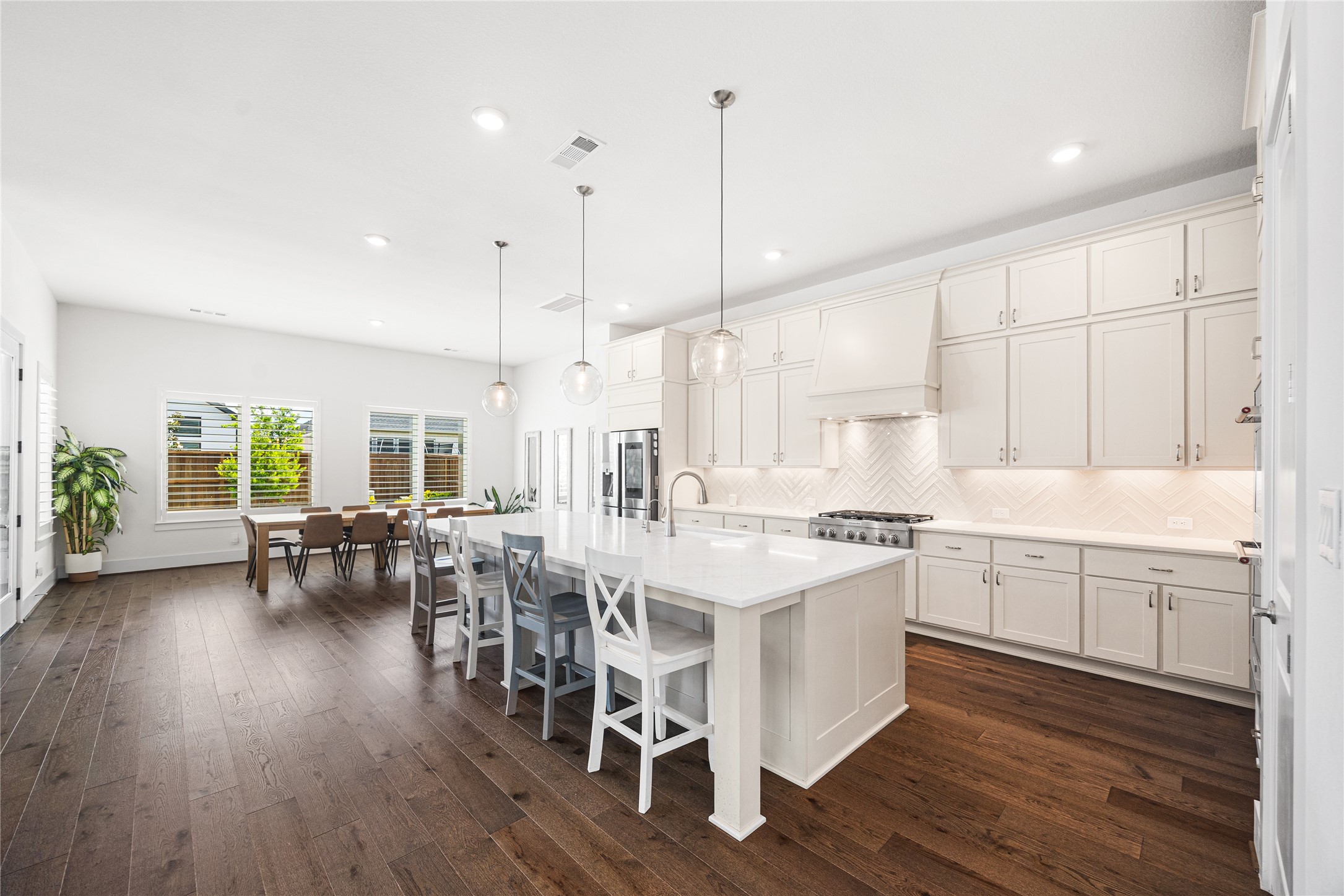 Kitchen-dining area centered around an oversized island, creating the perfect hub for gathering, casual dining, and entertaining.