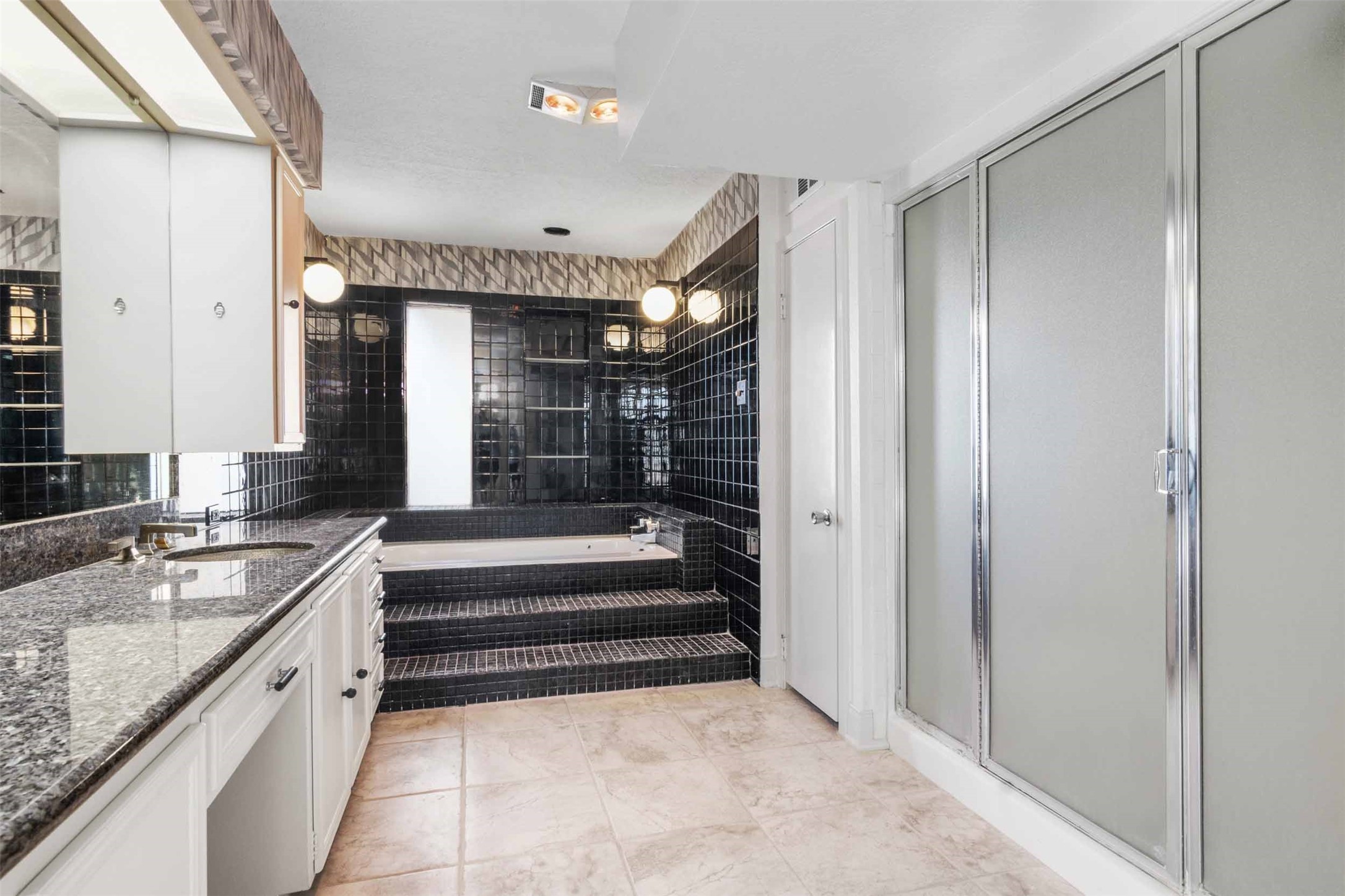 Elaborate primary bath with lovely tub, granite countertop, 2 sinks and large shower.