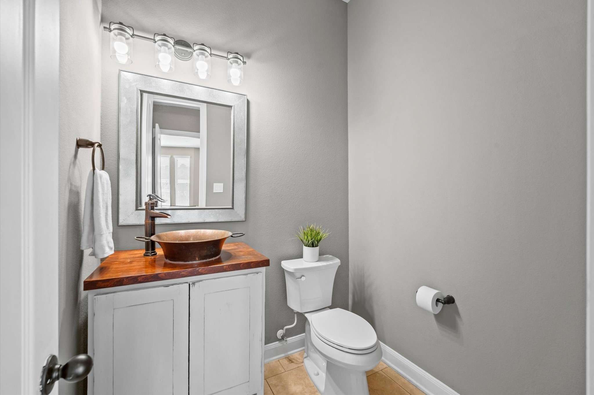 This convenient half bath is located near the flex space and media room.