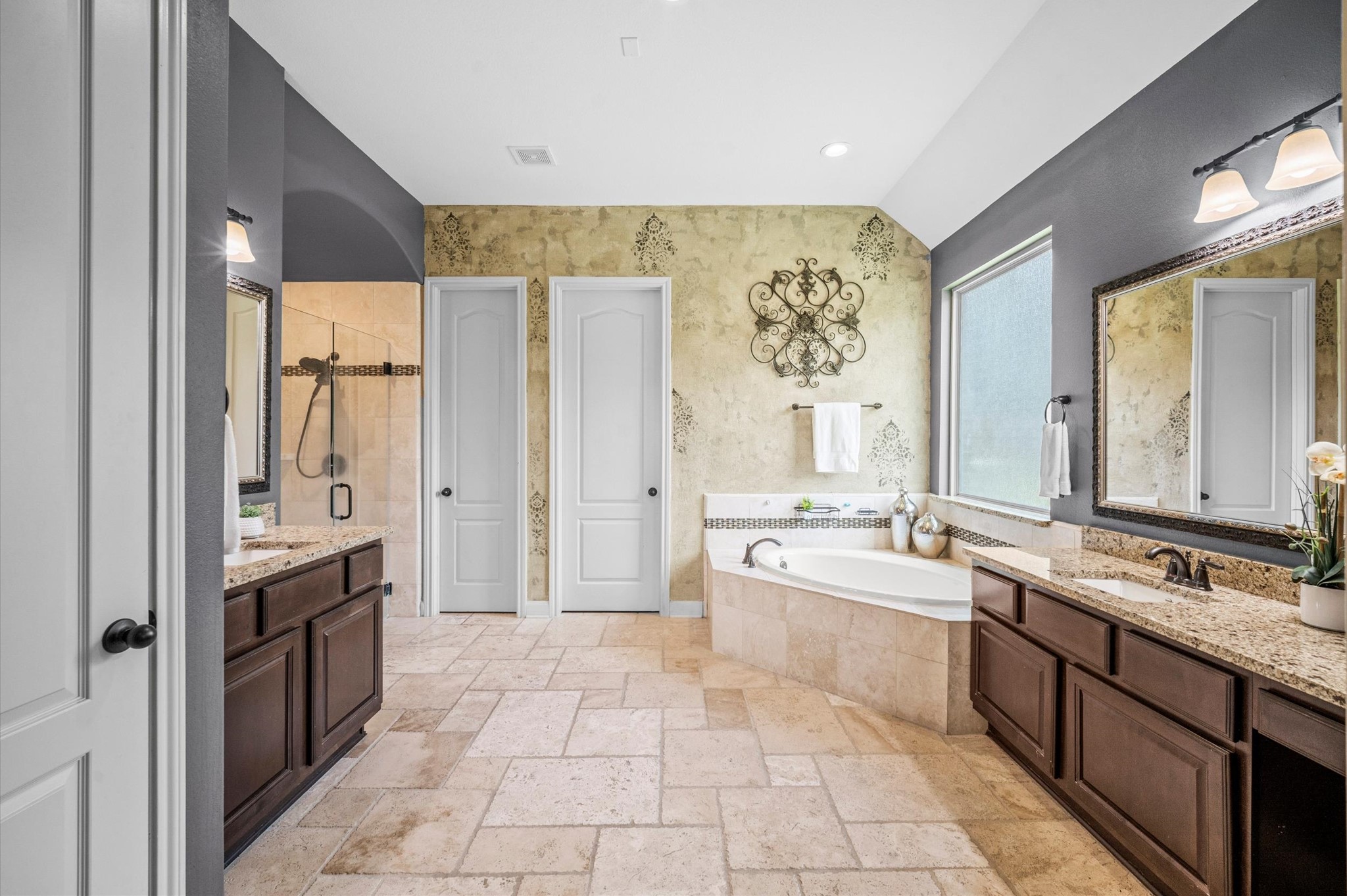 A second vanity rests across from the first, near the relaxing soaking tub.