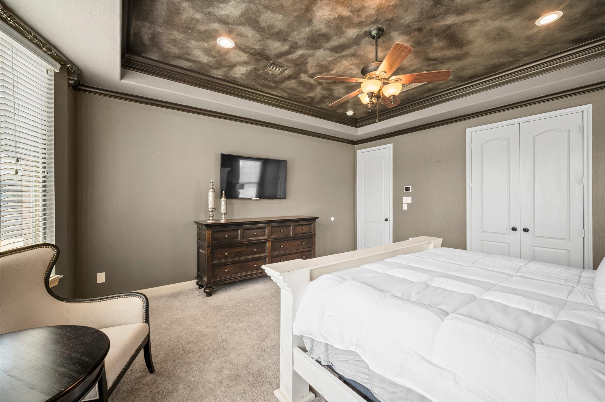 The elegant painted ceiling is a showstopper in this incredible primary retreat! The dark trim offers the perfect accent.