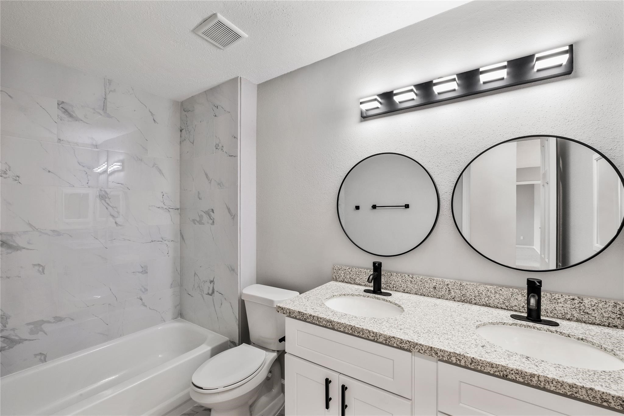 The upstairs shared bathroom features a granite vanity, updated fixtures, and a tub/shower combination with modern finishes.
