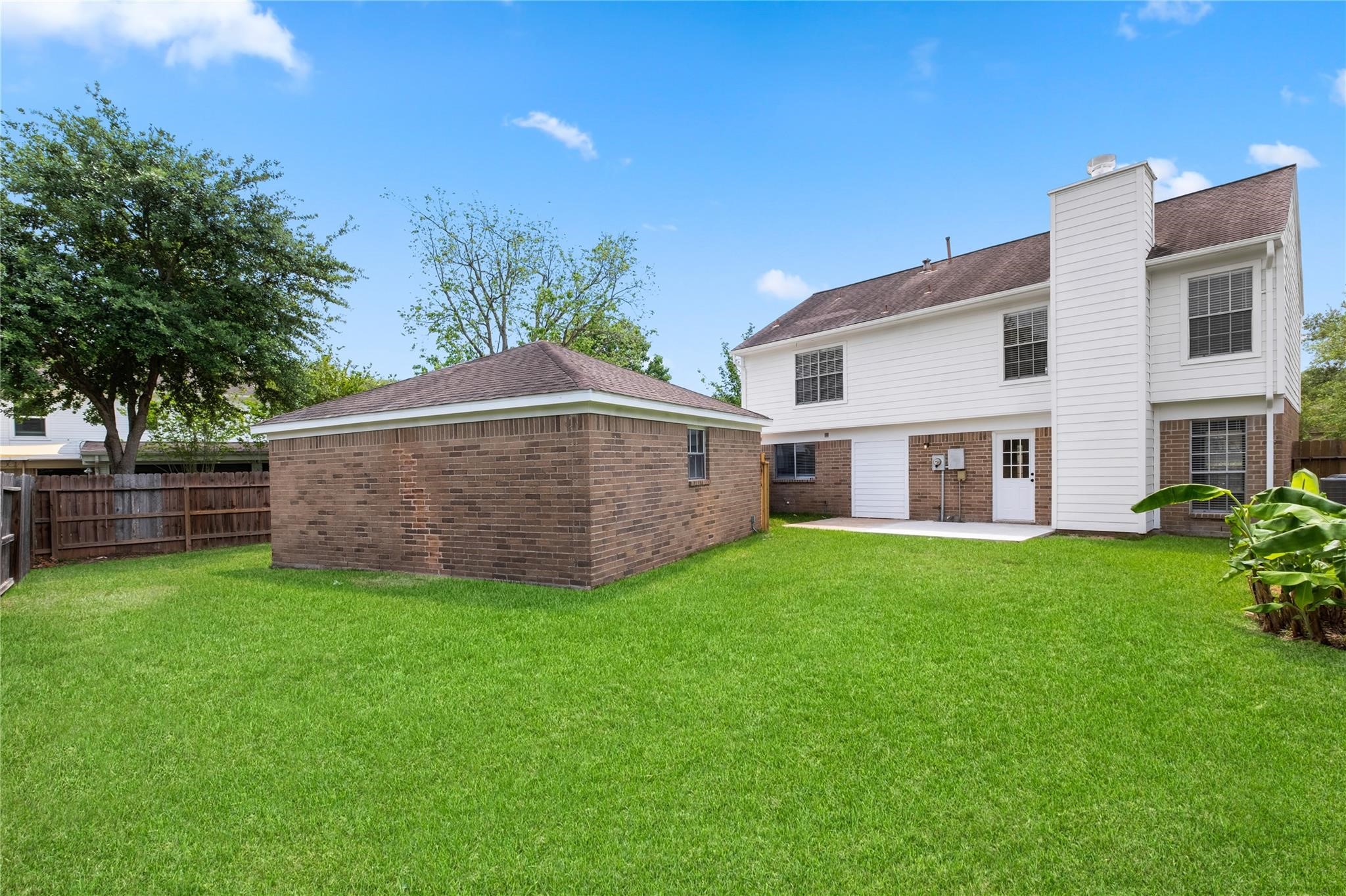 The fully fenced backyard offers plenty of green space for outdoor enjoyment and includes a detached two-car garage with additional room for storage.