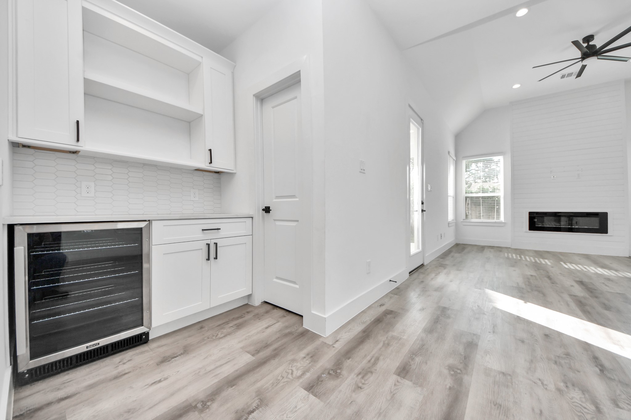 Built in dry bar with wine cooler, storage space, countertop space for appliances and open shelving for displaying decor.