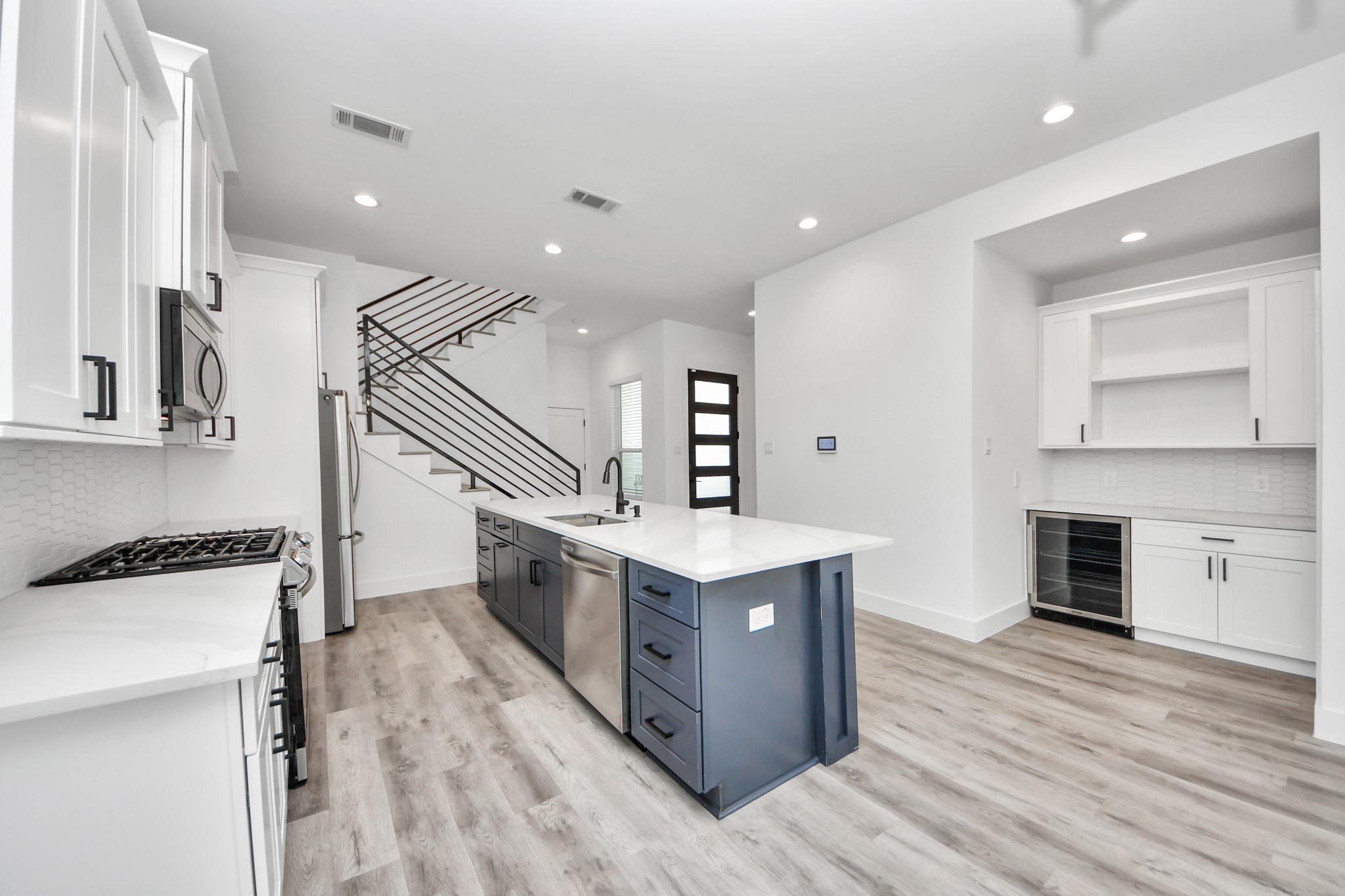 Large gourmet kitchen island featuring plenty of storage space with built-in breakfast bar seating.