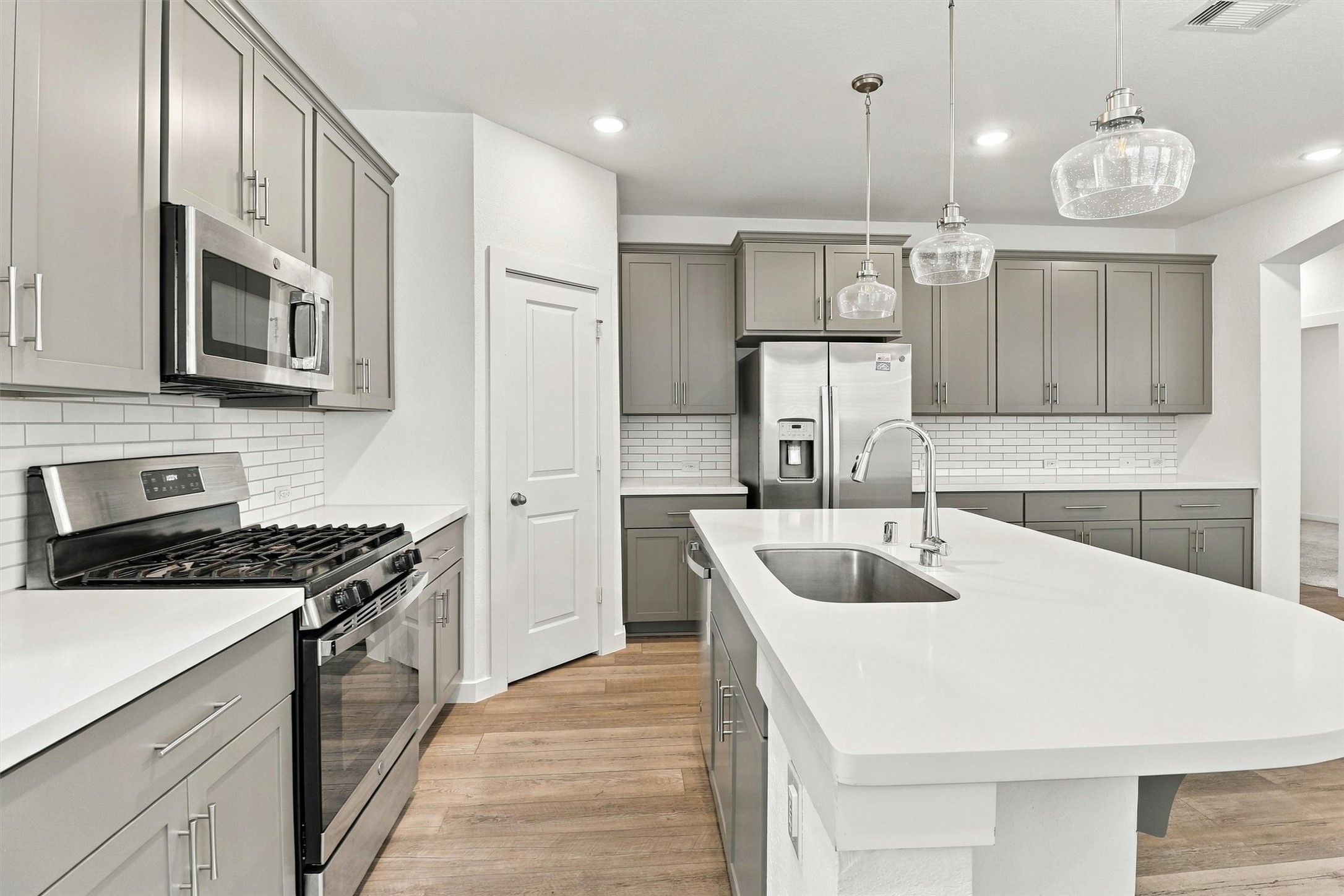 This gourmet kitchen has it all! The owner just refinished all of the cabinetry (9/2026) with new paint and soft close doors. This kitchen also features pendant lighting, stainless steel appliances, gas range, microwave, dishwasher, subway tile backsplash, and large island for cooking and entertaining!