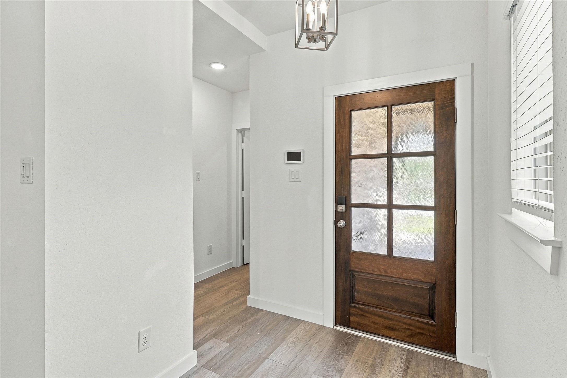Entry way with custom pendant light and beautiful window. Directly to the Left, find the laundry room and garage entry.