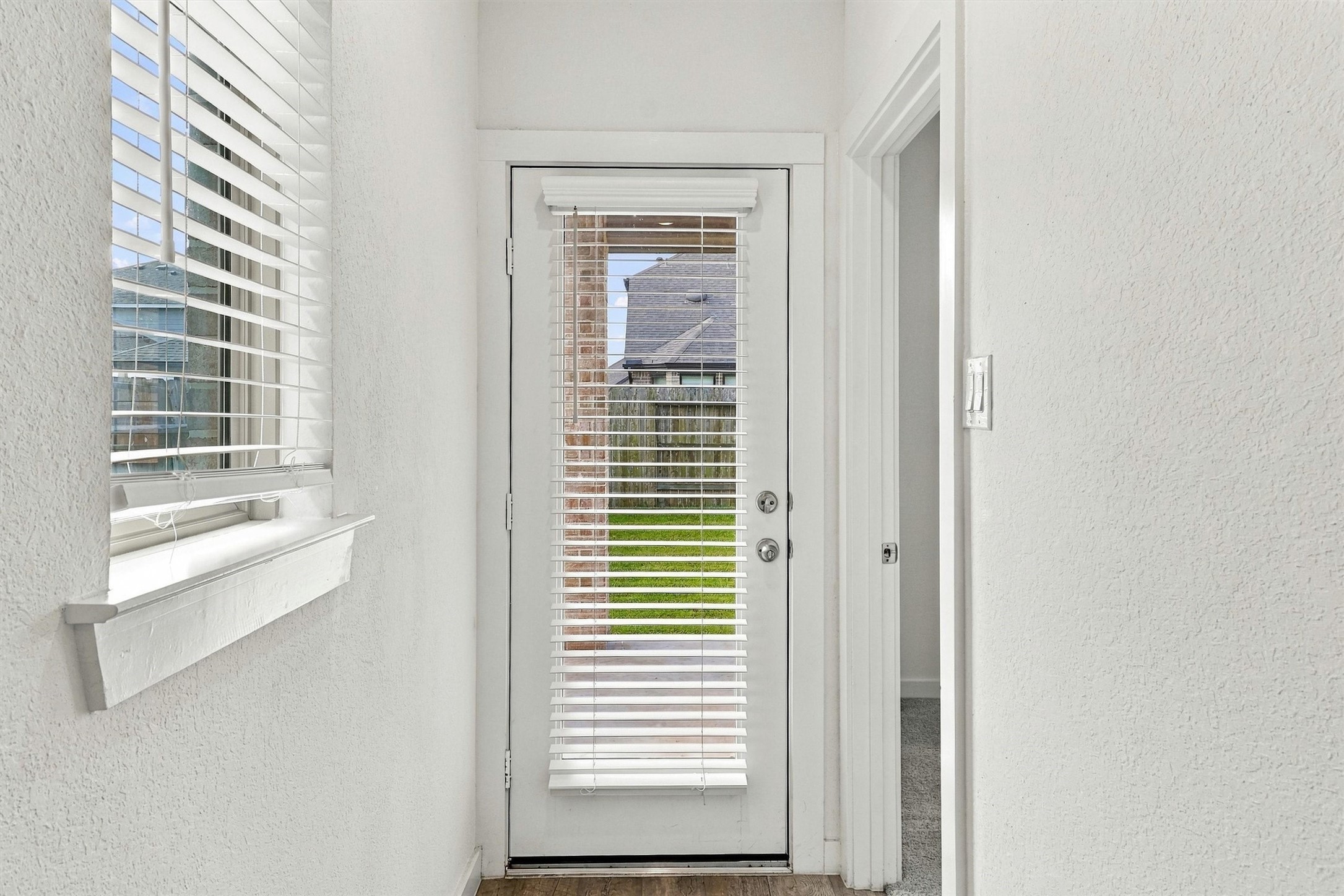 Directly beside the kitchen is a door to the covered patio and large backyard. The door to the Right is the Primary Suite!