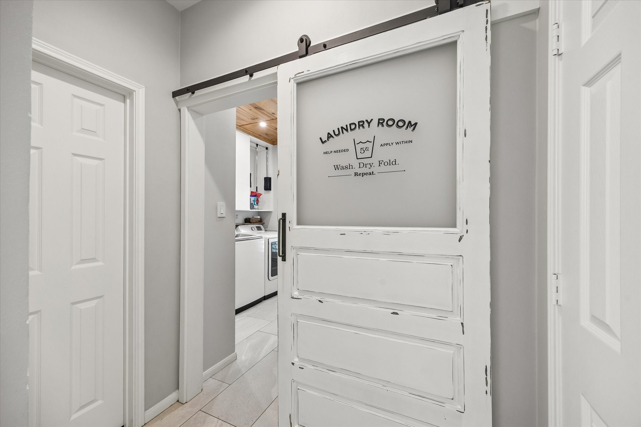 Even the practical spaces have a little personality. A rustic sliding barn door opens to the laundry room, adding a charming architectural detail to an everyday part of the home.