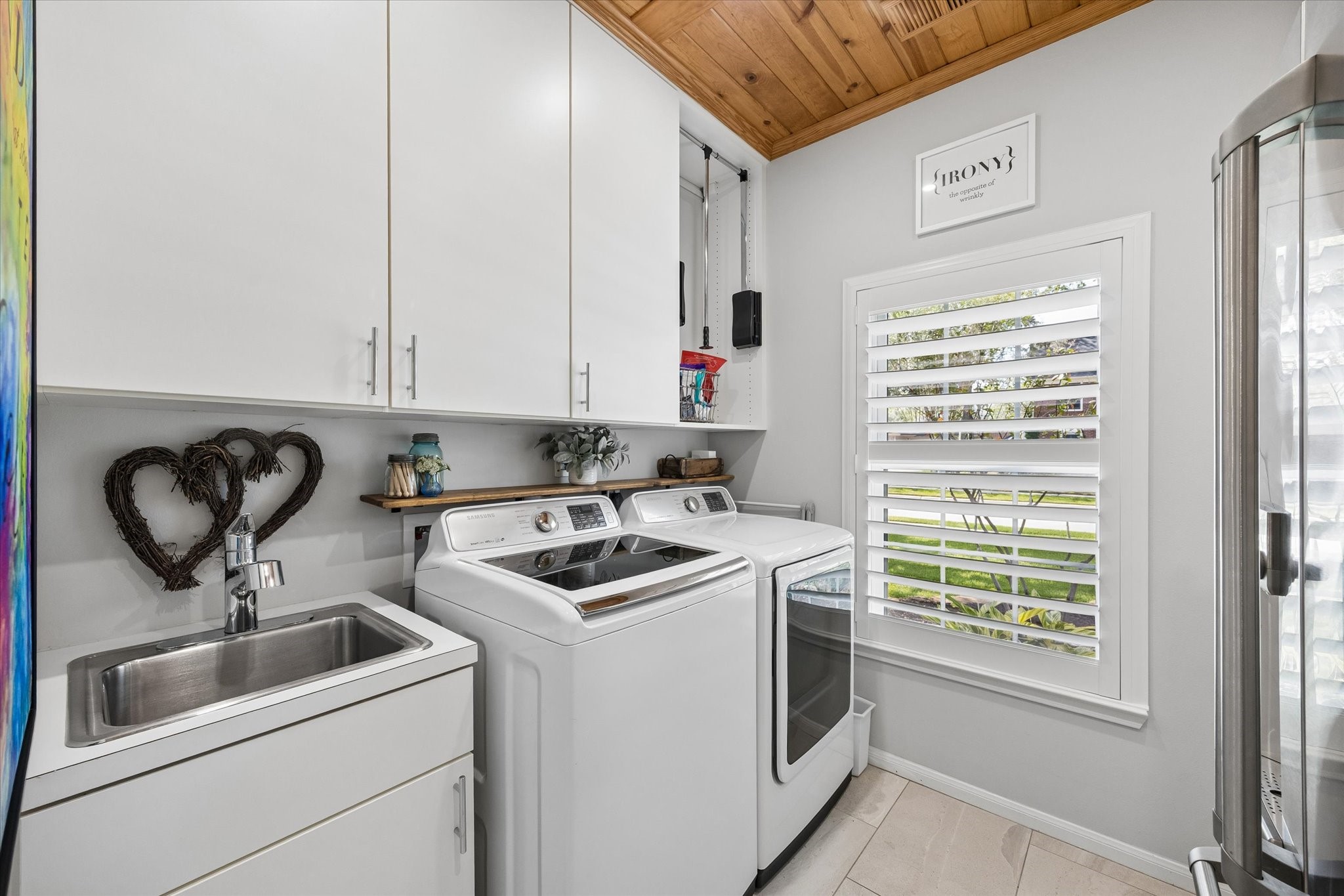 Laundry day feels a little easier with generous cabinetry, a utility sink, and a bright, organized space designed to make everyday chores more convenient.