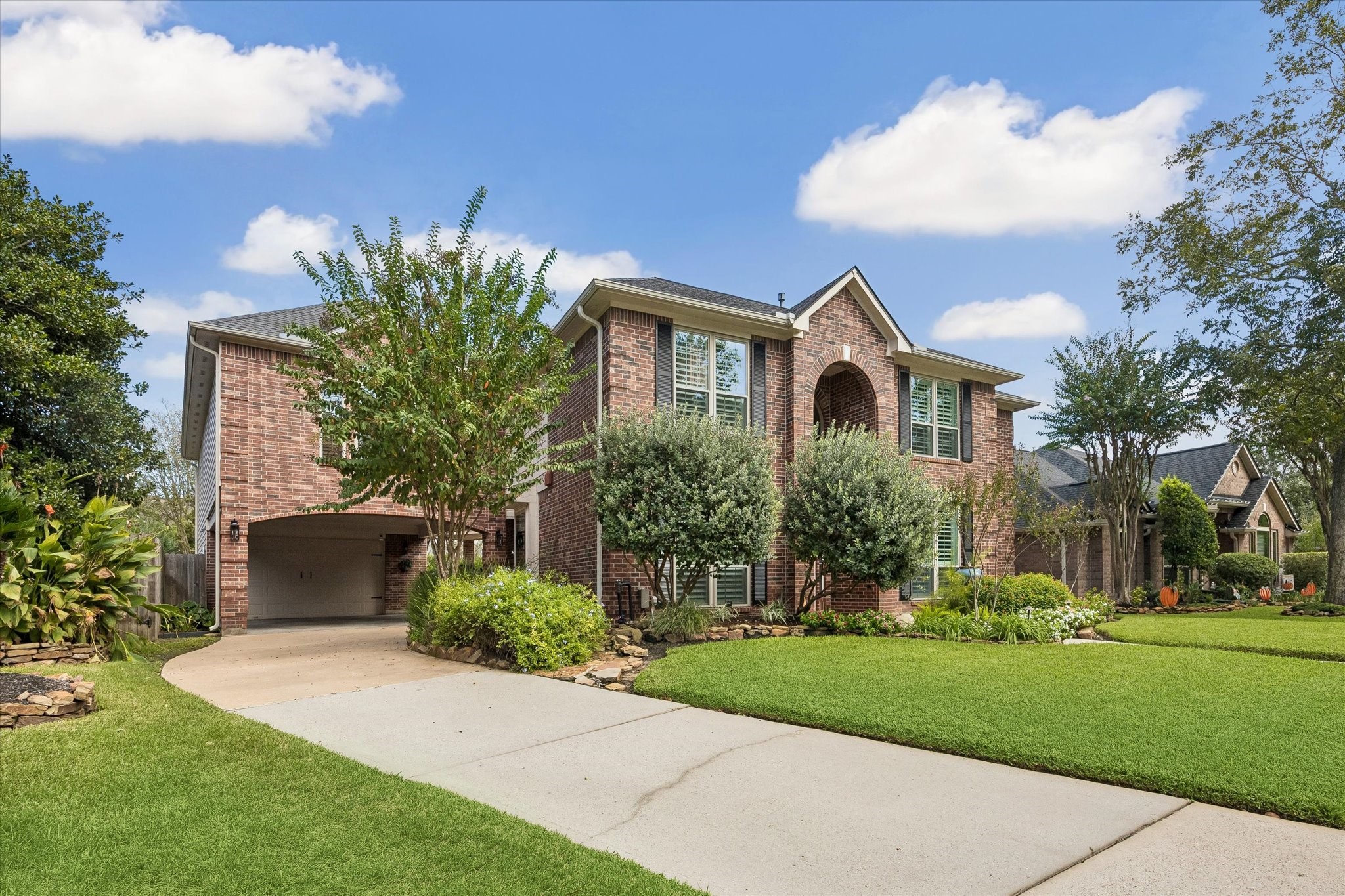 A convenient porte cochere provides covered access and leads toward the garage, combining practical everyday function with the home's traditional architecture.