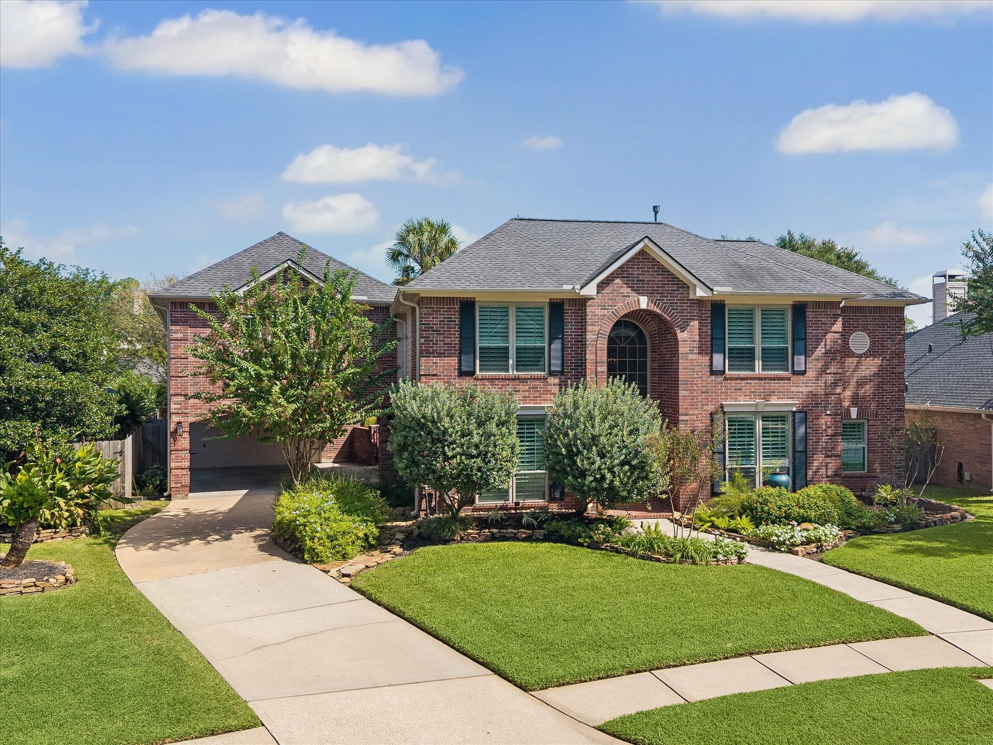 A beautiful place to come home to! Timeless brick architecture, mature trees, and lush landscaping create an inviting setting, while the home's impressive design hints at the exceptional living spaces and thoughtful details waiting inside.