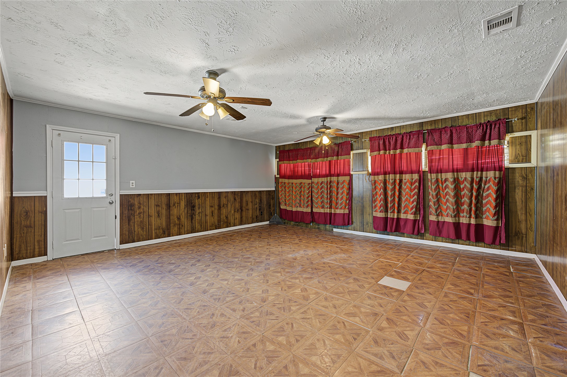 Spacious living and entertaining area featuring a mix of rich wood paneling and fresh interior paint.