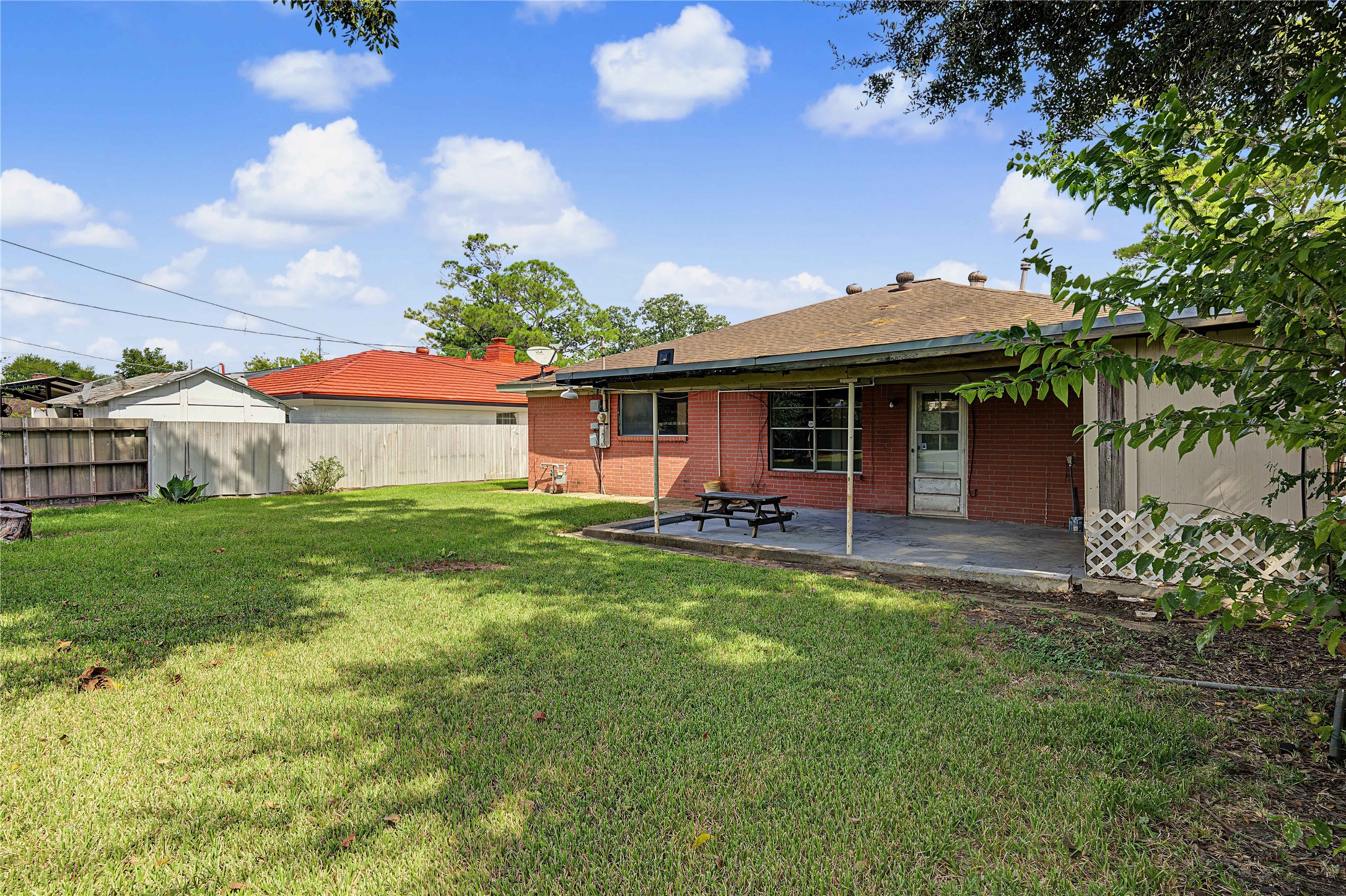 Rear exterior view showcasing the patio area and generous lot potential.