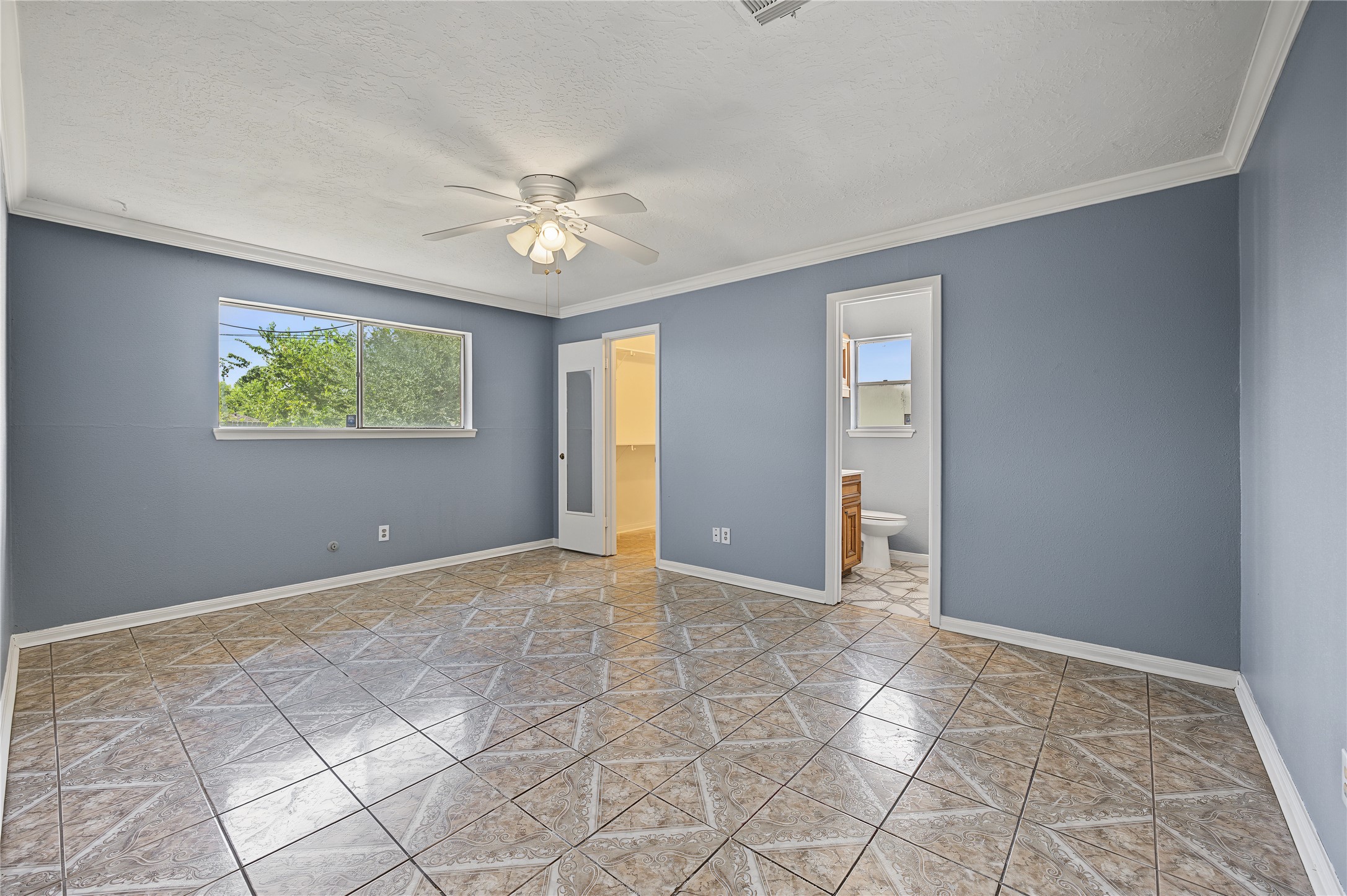 Generously sized primary bedroom featuring fresh interior paint and great natural light.