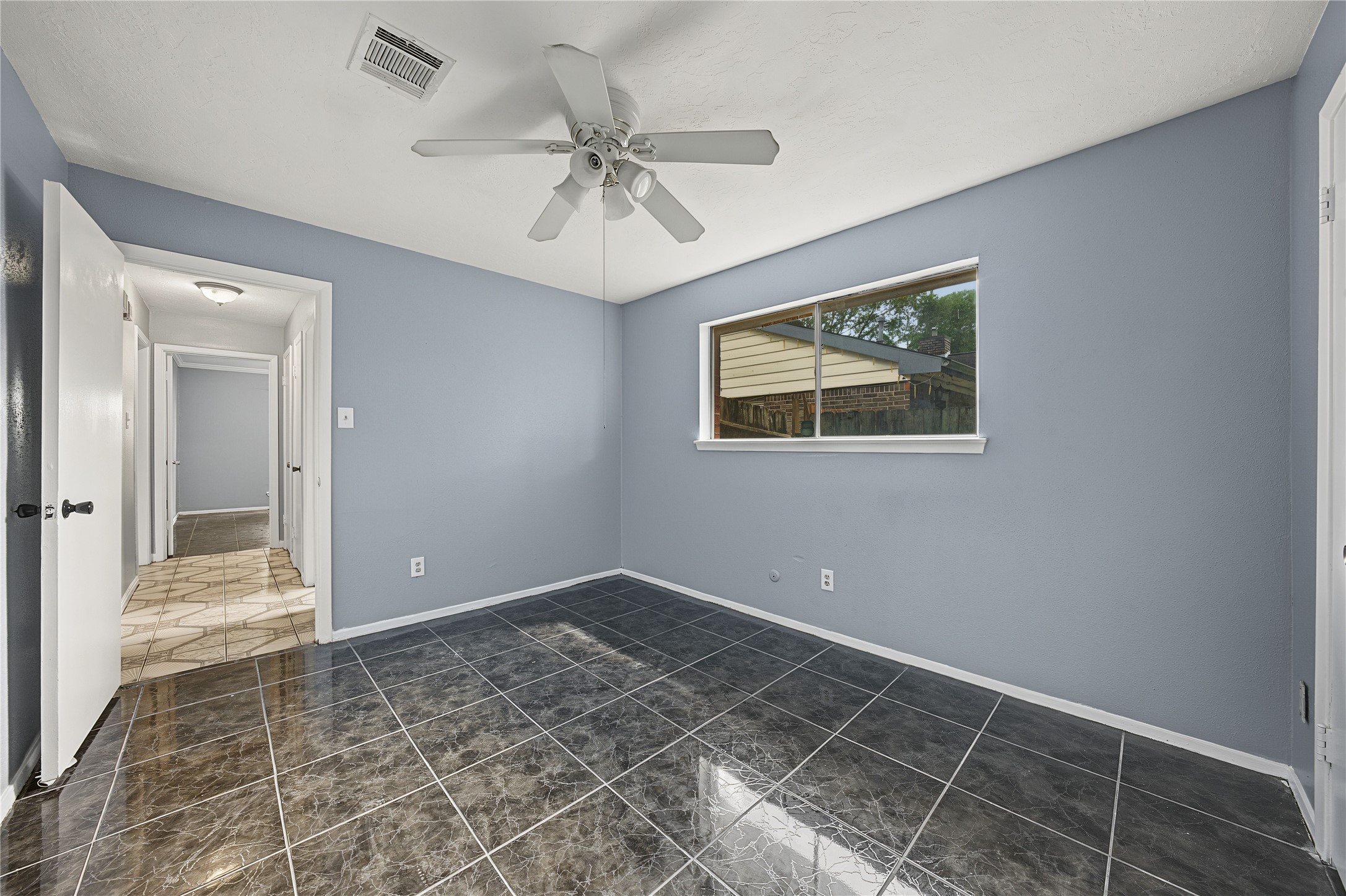Secondary bedroom featuring fresh interior paint and tile flooring.