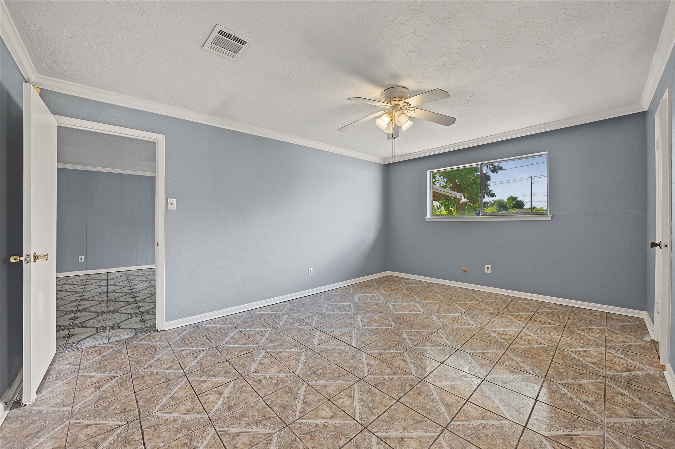 Primary suite showcasing newly painted walls, tile flooring, and a bright, clean feel.