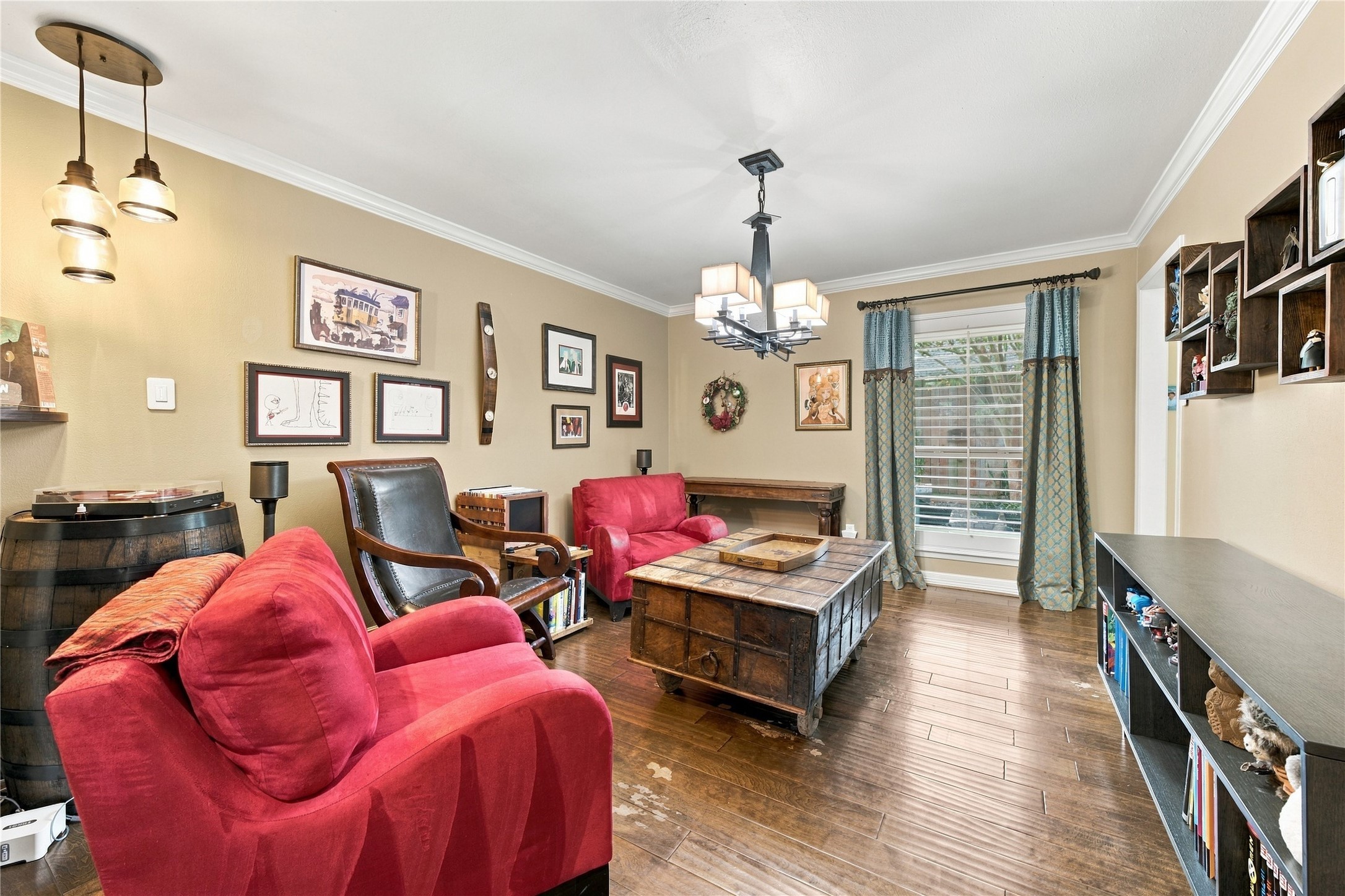 From the opposite corner, a pair of glass pendant lights adds warm accent lighting, and the doorway at the far end returns to the main hall.