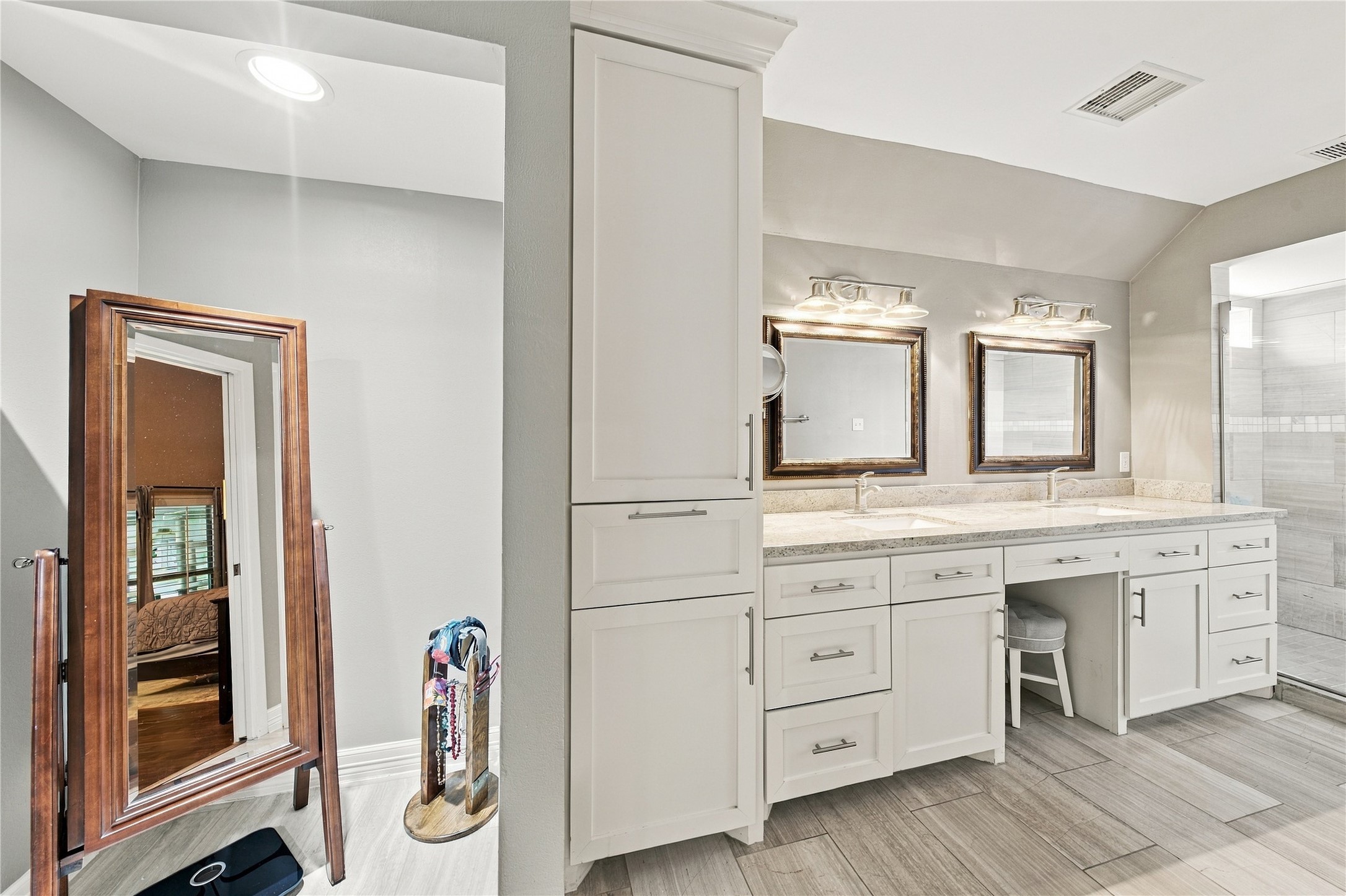 Additional cabinetry to the left of the double vanity offers excellent storage and additional linen space.