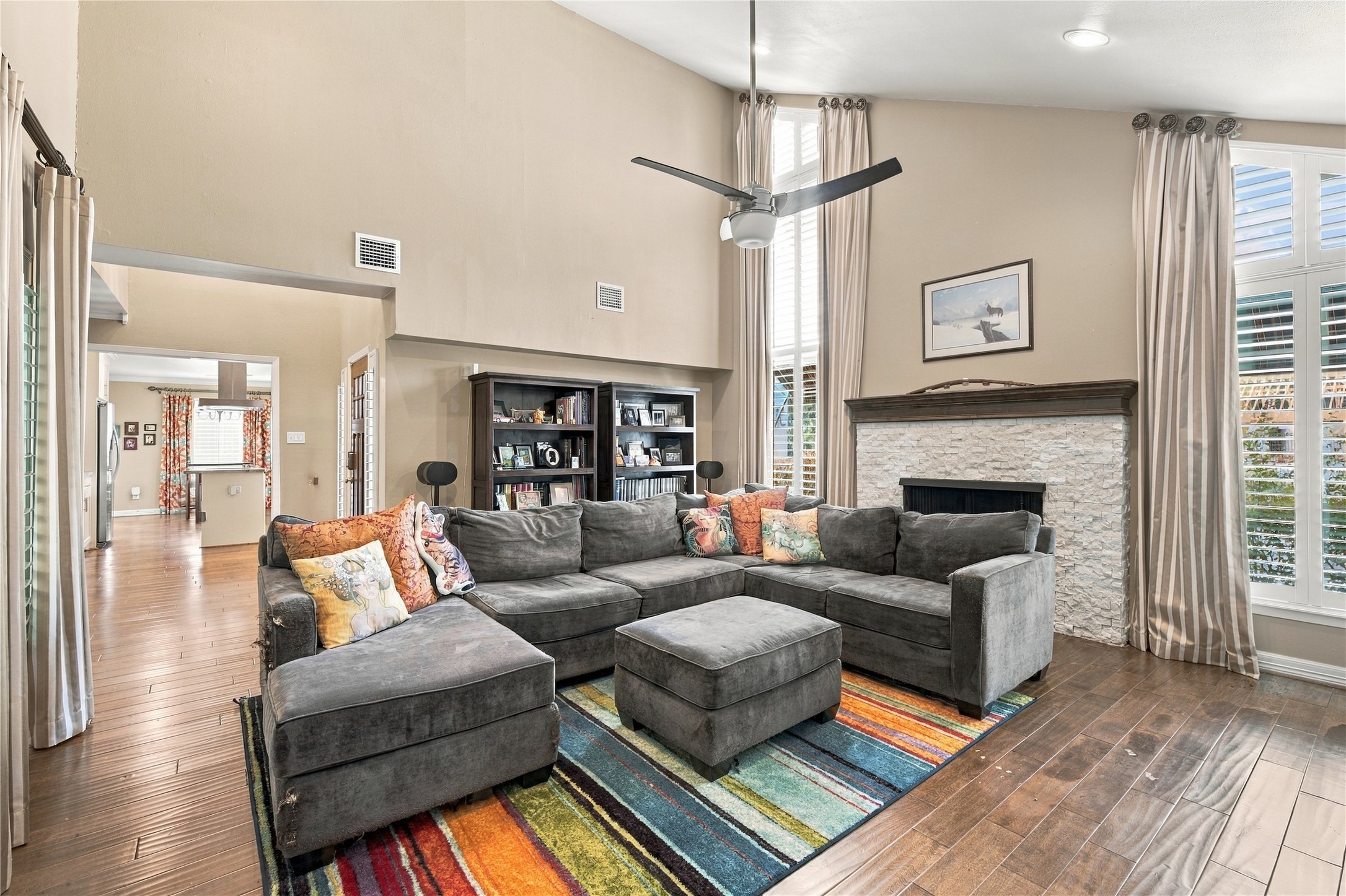 Another view of the living room shows the open flow into the kitchen & breakfast nook, with wood floors running seamlessly throughout. Ideal for everyday living & entertaining.