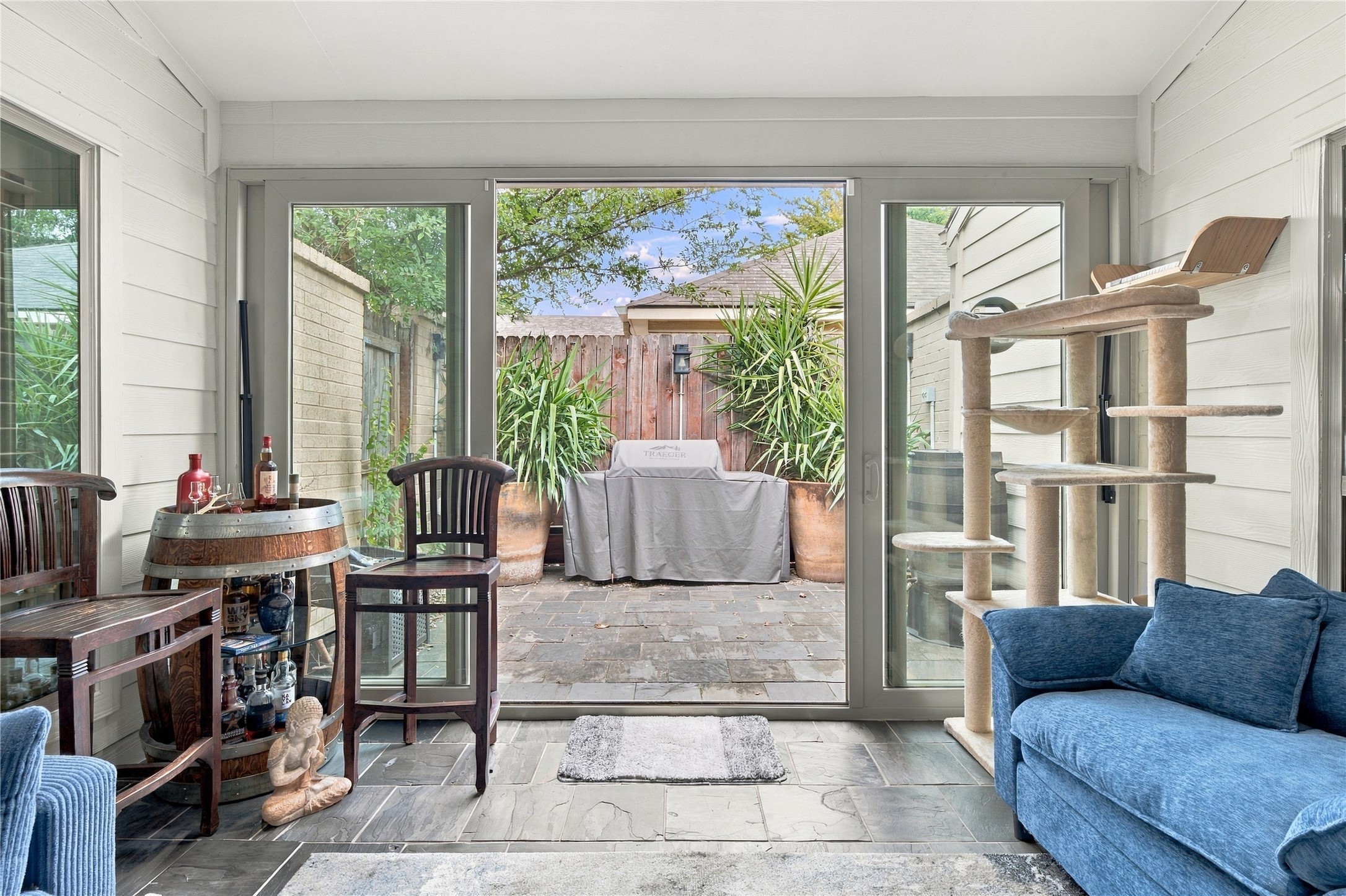 Wide sliding glass doors open the sunroom directly to one of the home's patios, letting the indoor & outdoor spaces work as one.