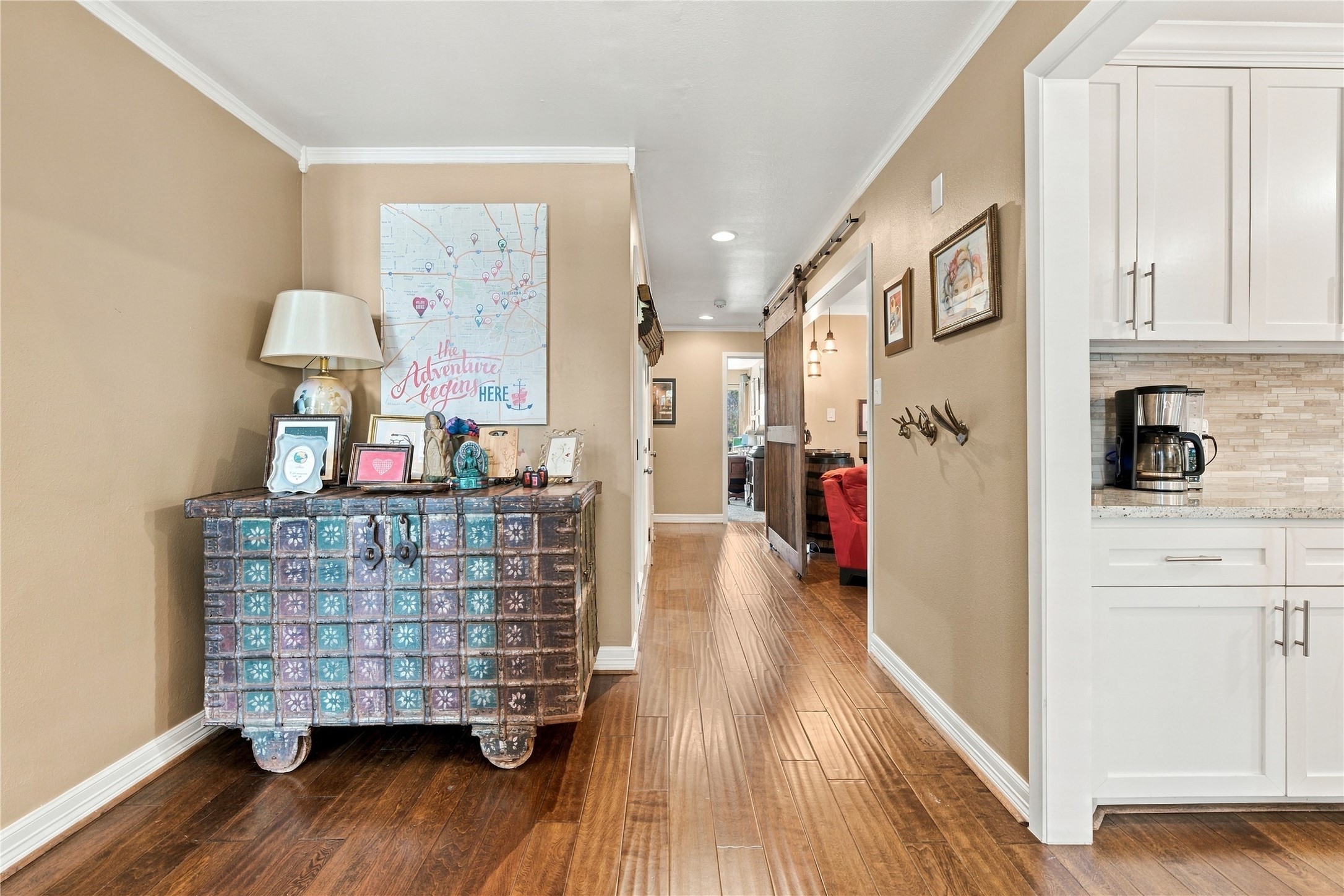 The dedicated entry way boasts engineered wood floors, crown molding & crisp white baseboards - The living room to the left and the kitchen to the right.