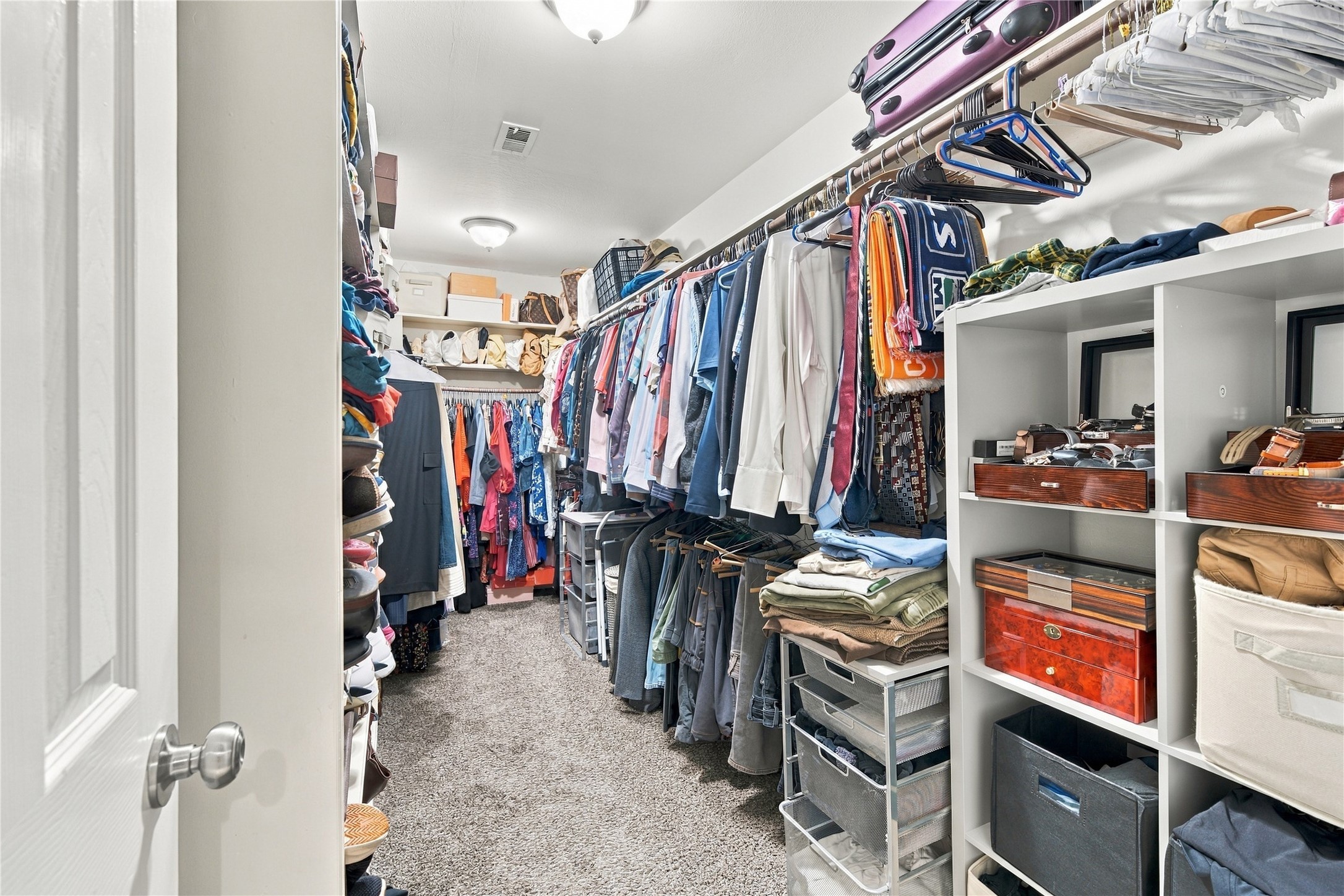 Spacious primary walk-in closet w/ long hanging rods & full-length shelving along the side wall, plus a second rod & shelf across the back. Plenty of room for a full wardrobe, shoes & seasonal storage.