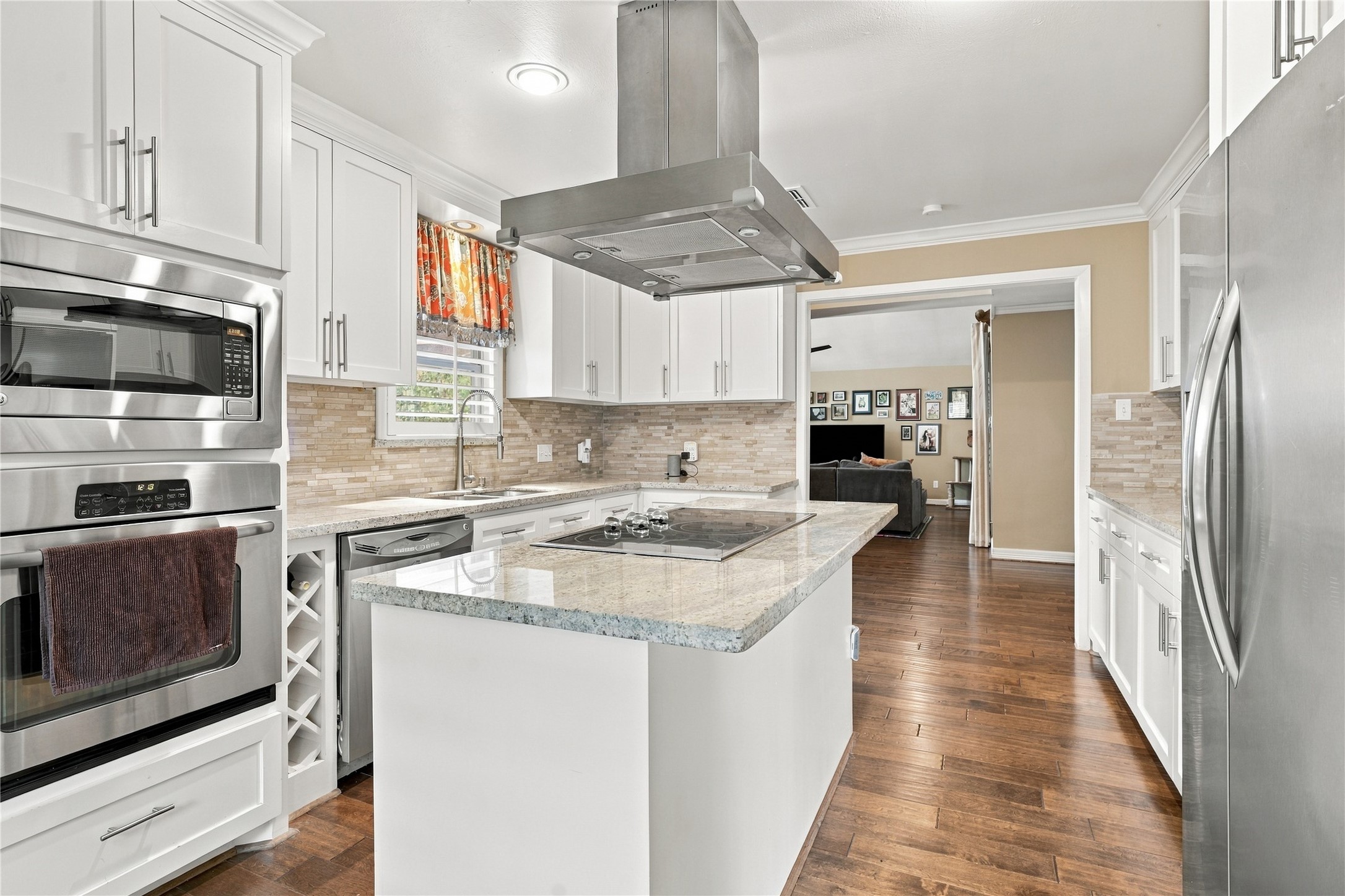 A built-in wall oven & microwave sit at the end of the cabinet run, a built-in wine rack beside the dishwasher and the granite island offering generous prep space round out this stunning kitchen.