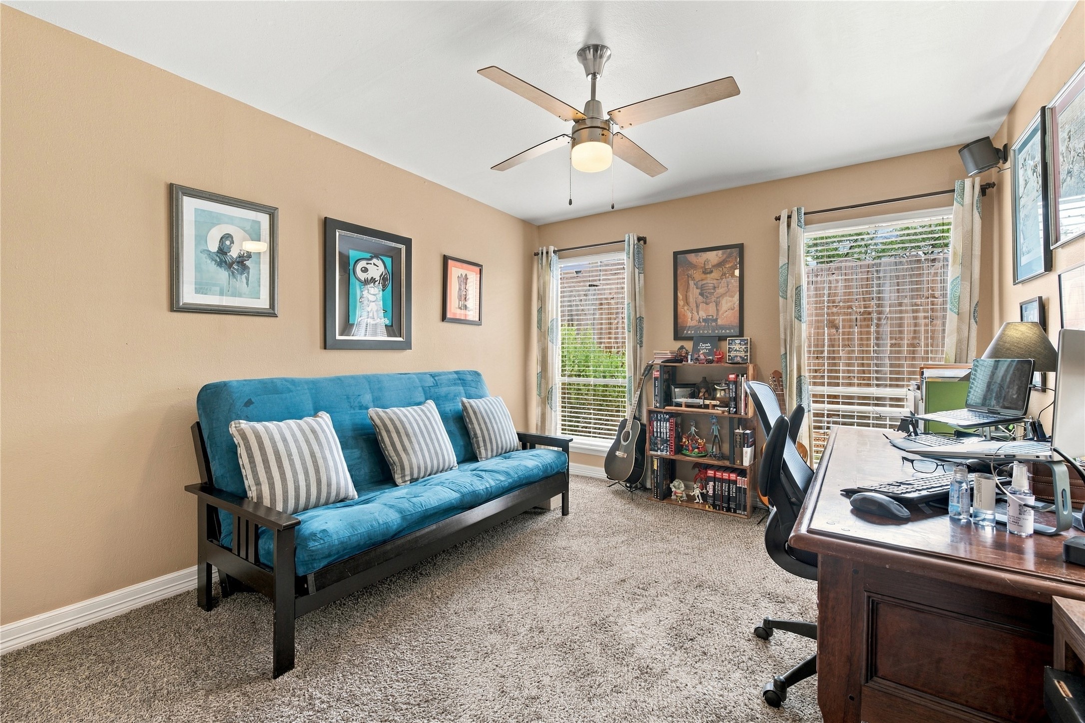 Secondary bedroom features plush carpet, a ceiling fan & two windows that bring in plenty of natural light. Currently set up as an office, it works equally well as a bedroom or guest room.