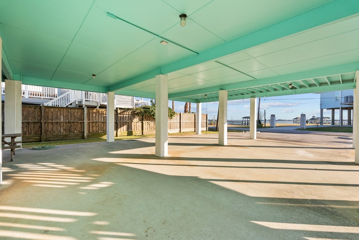 Spacious covered carport featuring sturdy support columns and a fenced backyard. Offers easy access to nearby amenities.