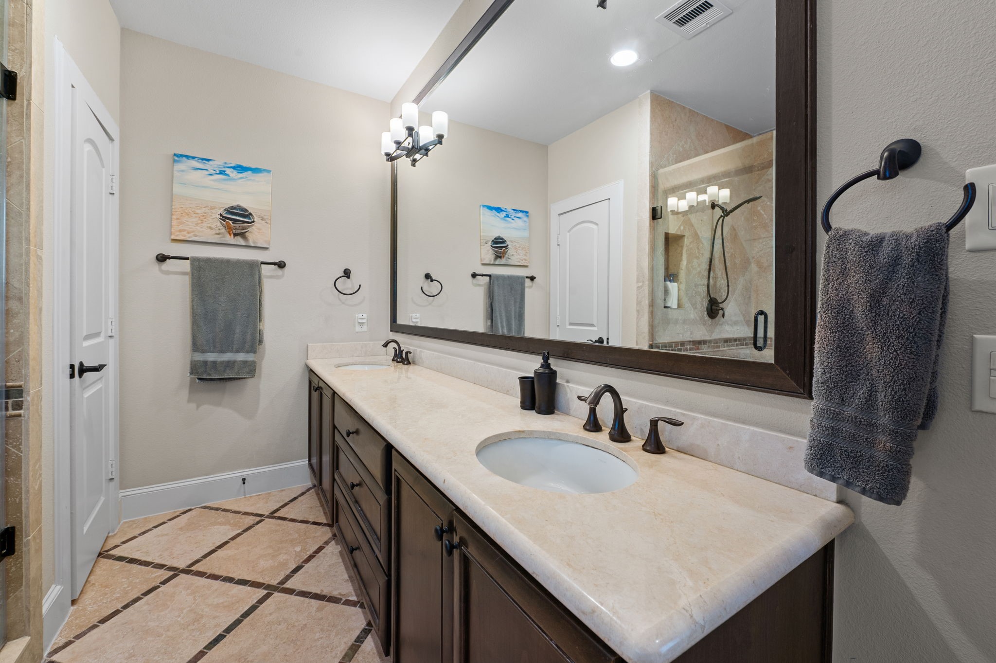 Another view of the primary bath with double sinks and a huge mirror and counter top space.