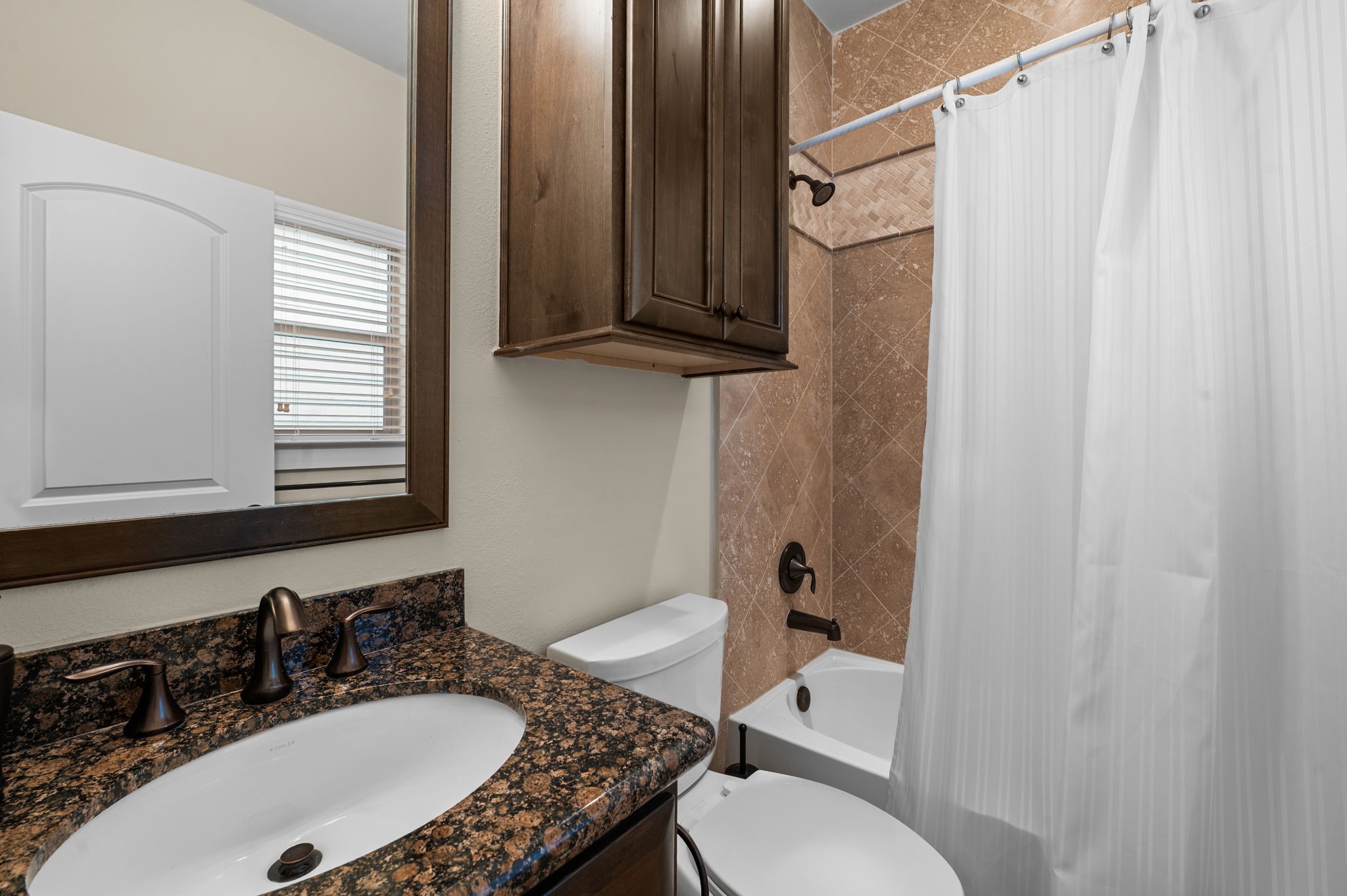 Bedroom 3 is located on the first floor and boasts a walk in closet, ensuite bathroom, and wood floors.
