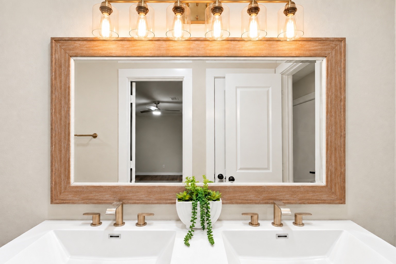 Upclose view of the light fixtures and the mirror that stays with the home!