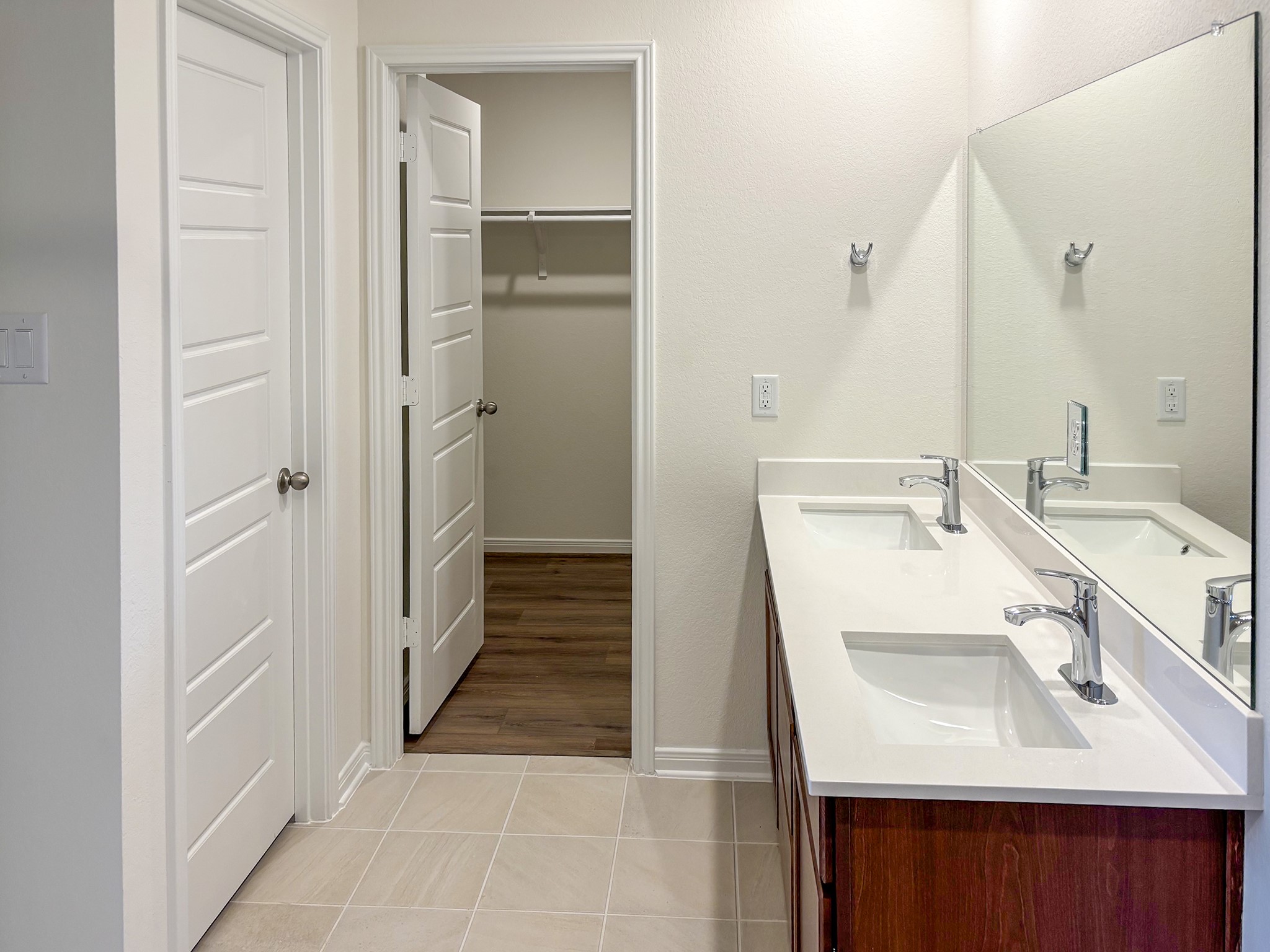 The ensuite primary bedroom has double sinks and a large walk-in closet,