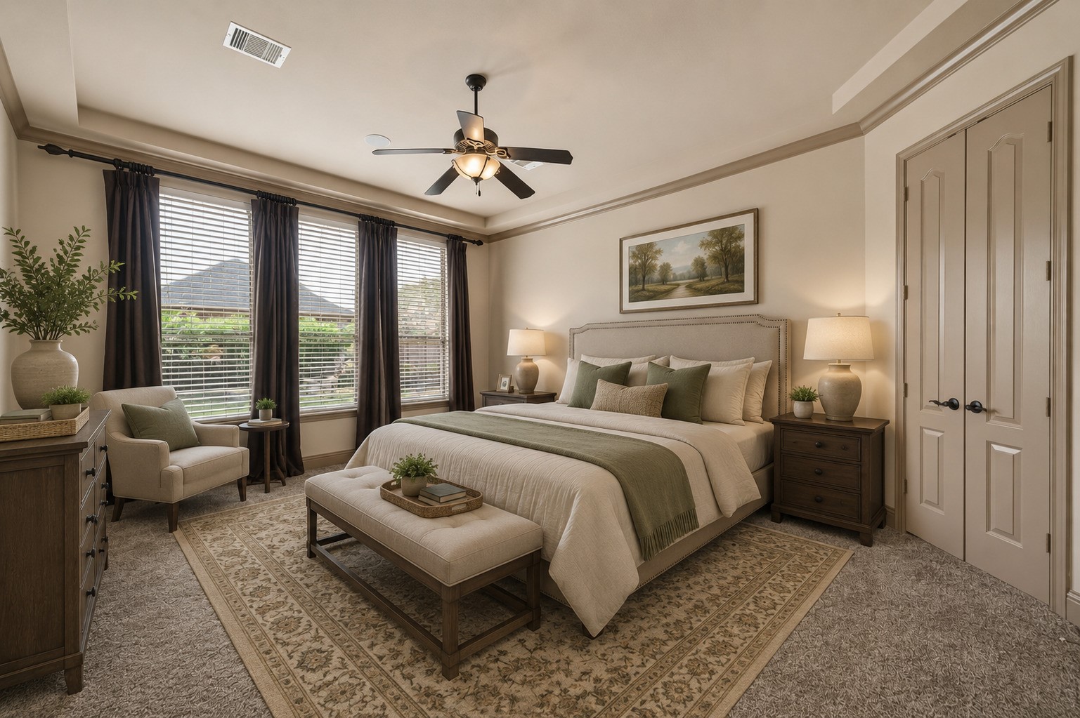 The spacious primary bedroom features a tray ceiling with crown molding, a ceiling fan, and large windows with drapery that allow natural light to pour in. Plush carpeting adds warmth, while the generous layout provides room for a sitting area. Double doors lead to the full entry closet for convenient access. Please note, this photo has been virtually staged.