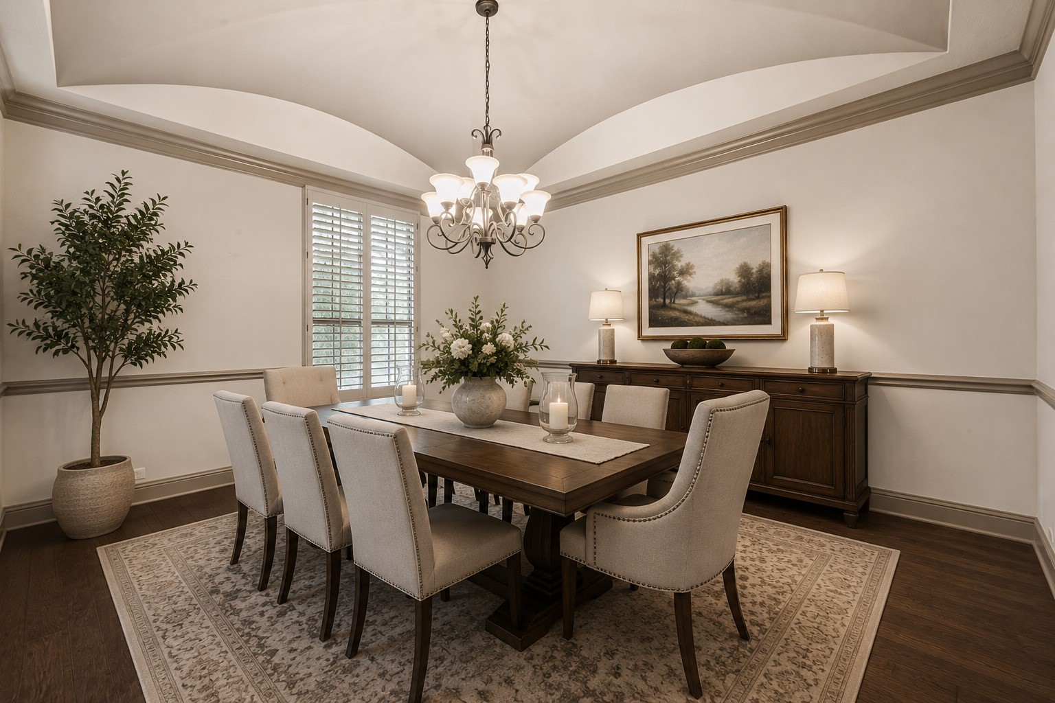This elegant formal dining room features a stunning tray ceiling with crown molding and a chandelier that casts a warm, inviting glow over the space. Hardwood flooring adds richness and sophistication, while plantation shutters filter in natural light. The room is spacious enough to accommodate a full-size dining table with seating for eight, making it the perfect setting for intimate dinners or memorable gatherings with loved ones. Please note, this photo has been virtually staged.