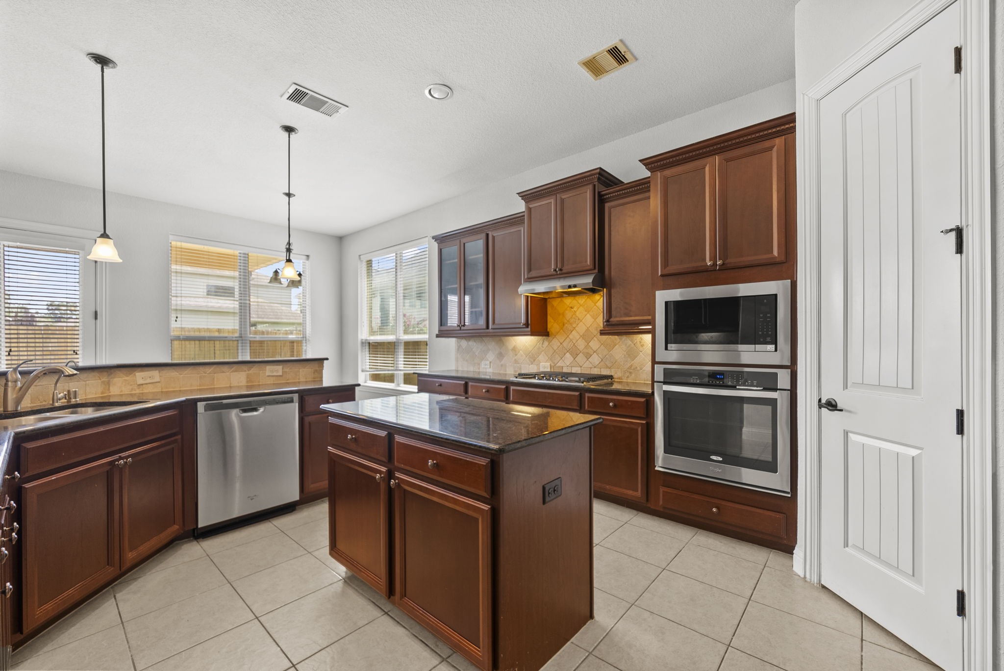 Chef-ready kitchen dazzles with rich cherry cabinetry, gleaming stainless steel appliances, and a center island ideal for prepping and gathering!