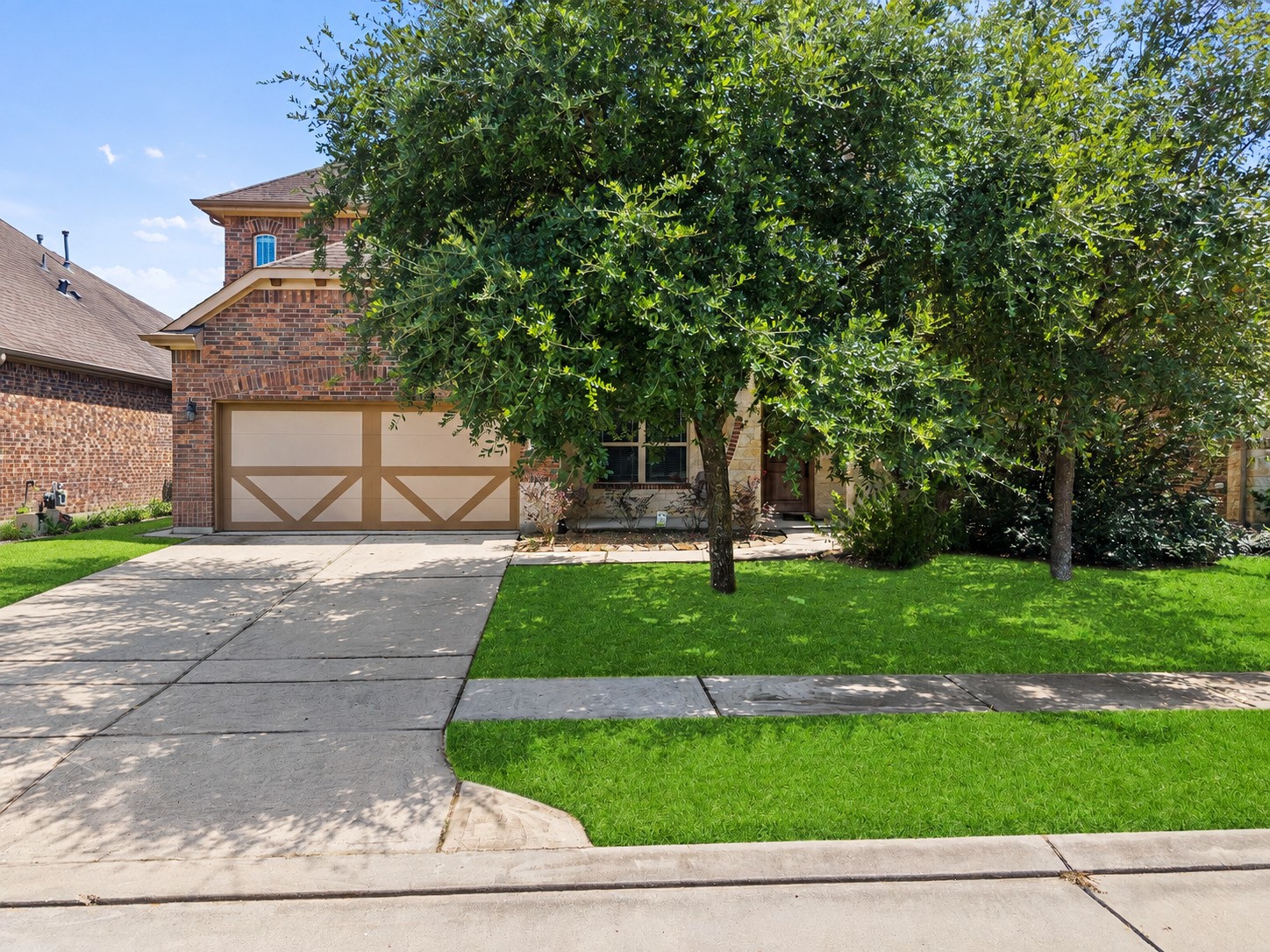 Charming brick two-story with a large shade tree anchoring a lush, manicured front lawn and spacious driveway, curb appeal that welcomes you home!