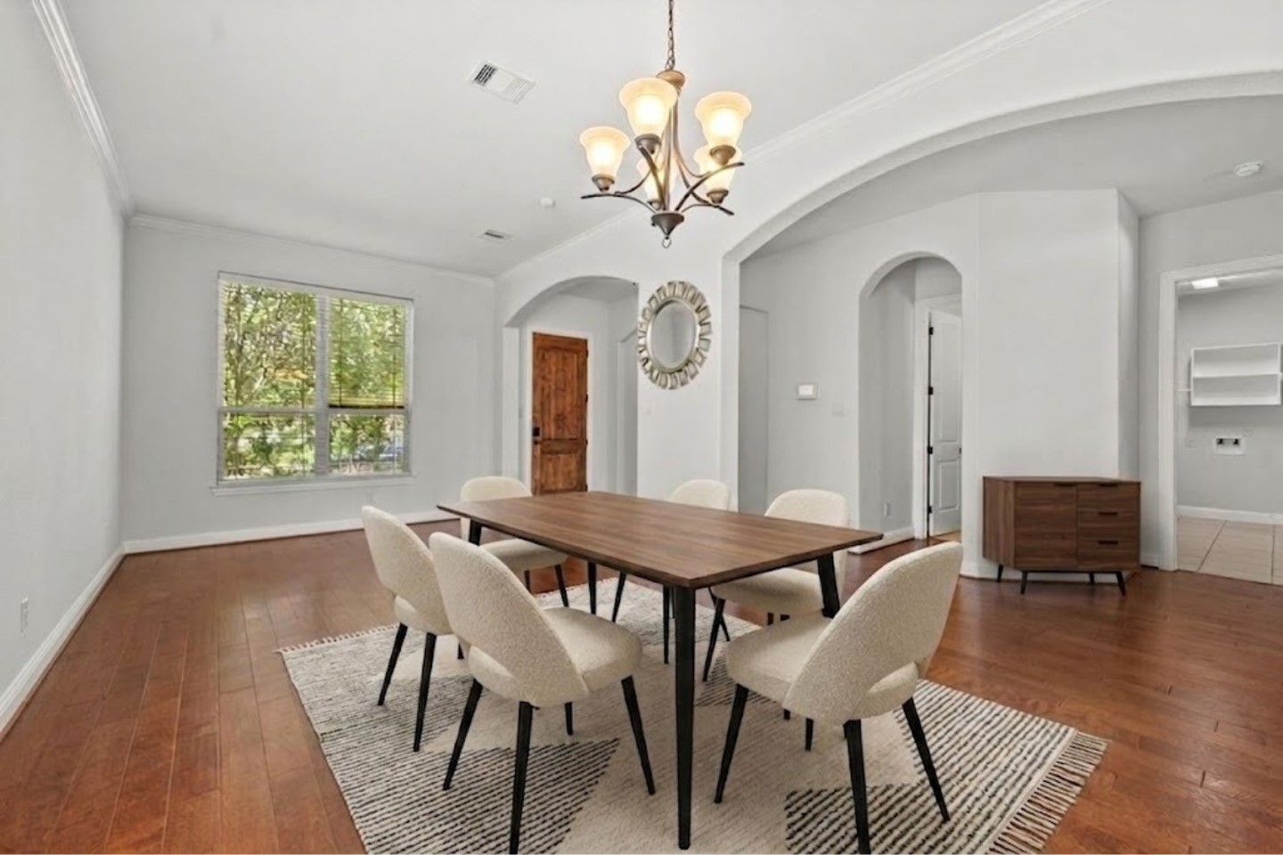 Virtually Stagged - Sun drenched entry showcases a beautiful chandelier, graceful archways, and warm hardwood floors flowing seamlessly into the heart of the home!
