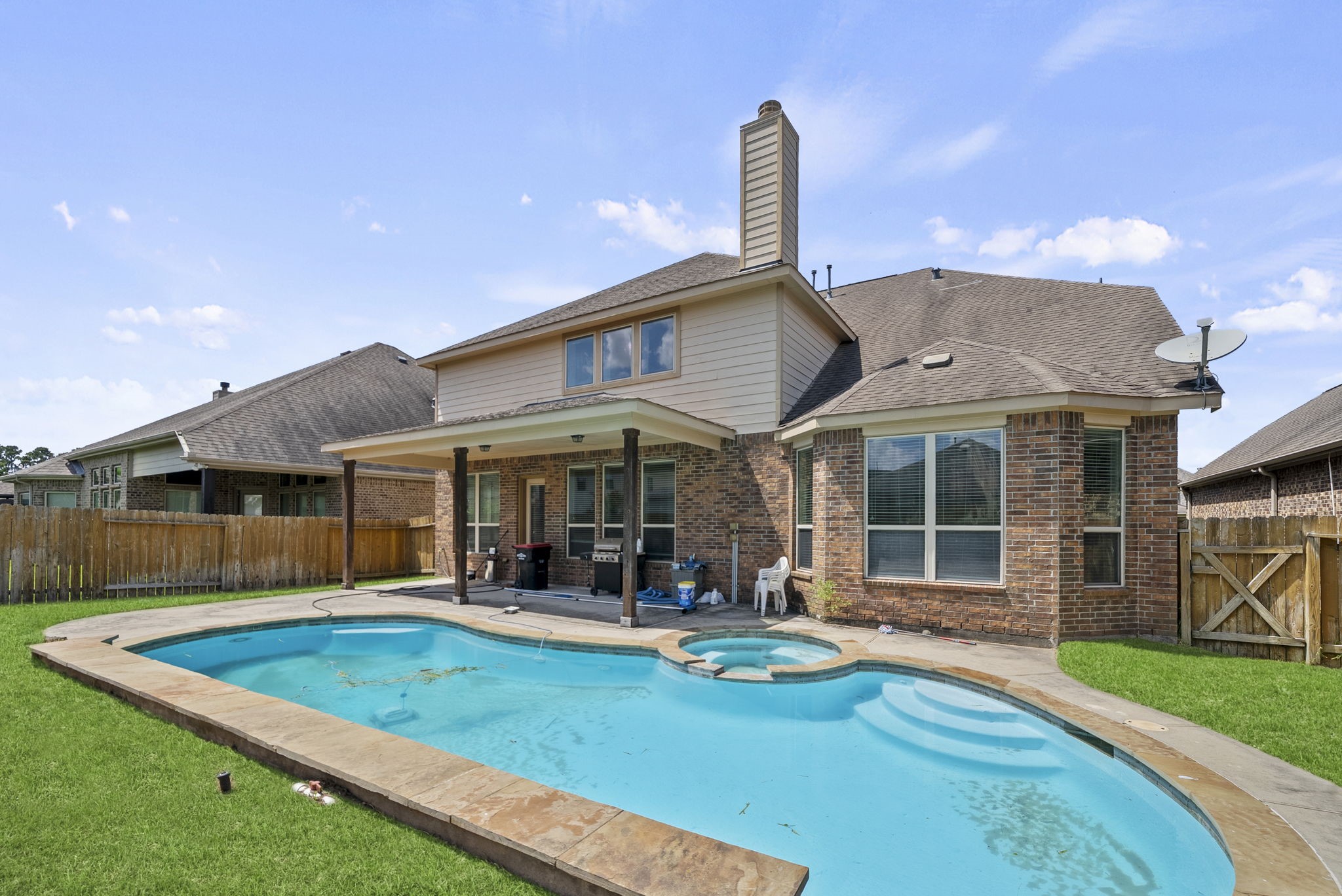 Stunning freeform pool and spa create the ultimate backyard oasis, a covered patio and privacy fencing make it ideal for entertaining and relaxing alike!