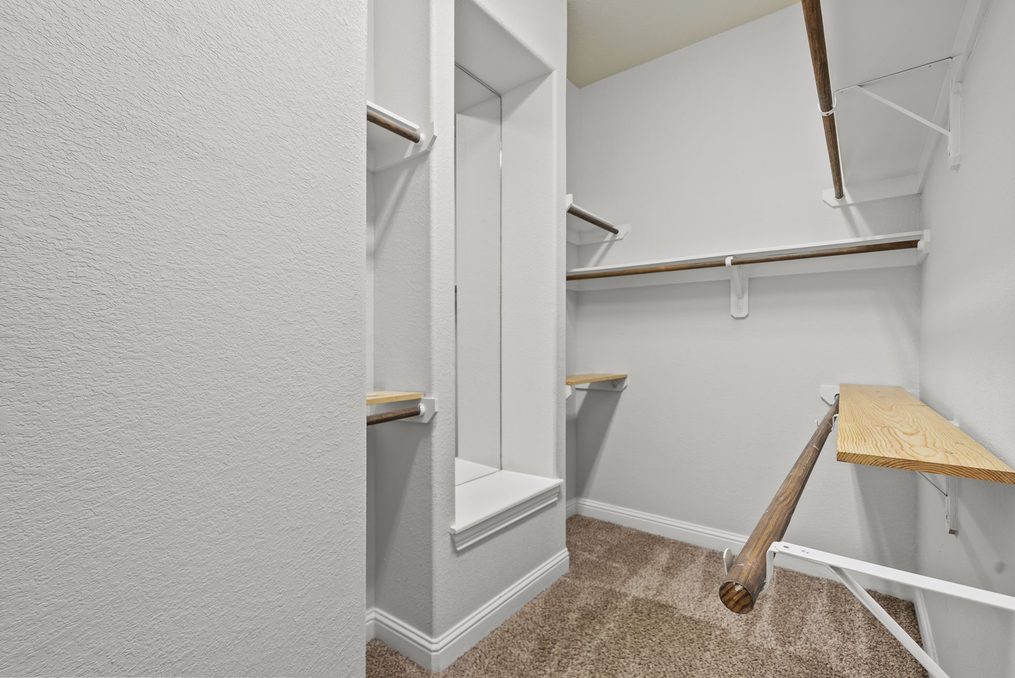 Walk-in closet features a built-in mirror nook and multiple hanging levels, thoughtful storage designed for effortless organization!