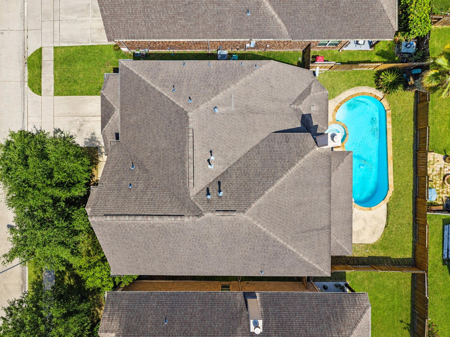 Breathtaking aerial perspective highlights the home's expansive roofline alongside a sparkling private pool, resort-style living right in the backyard!